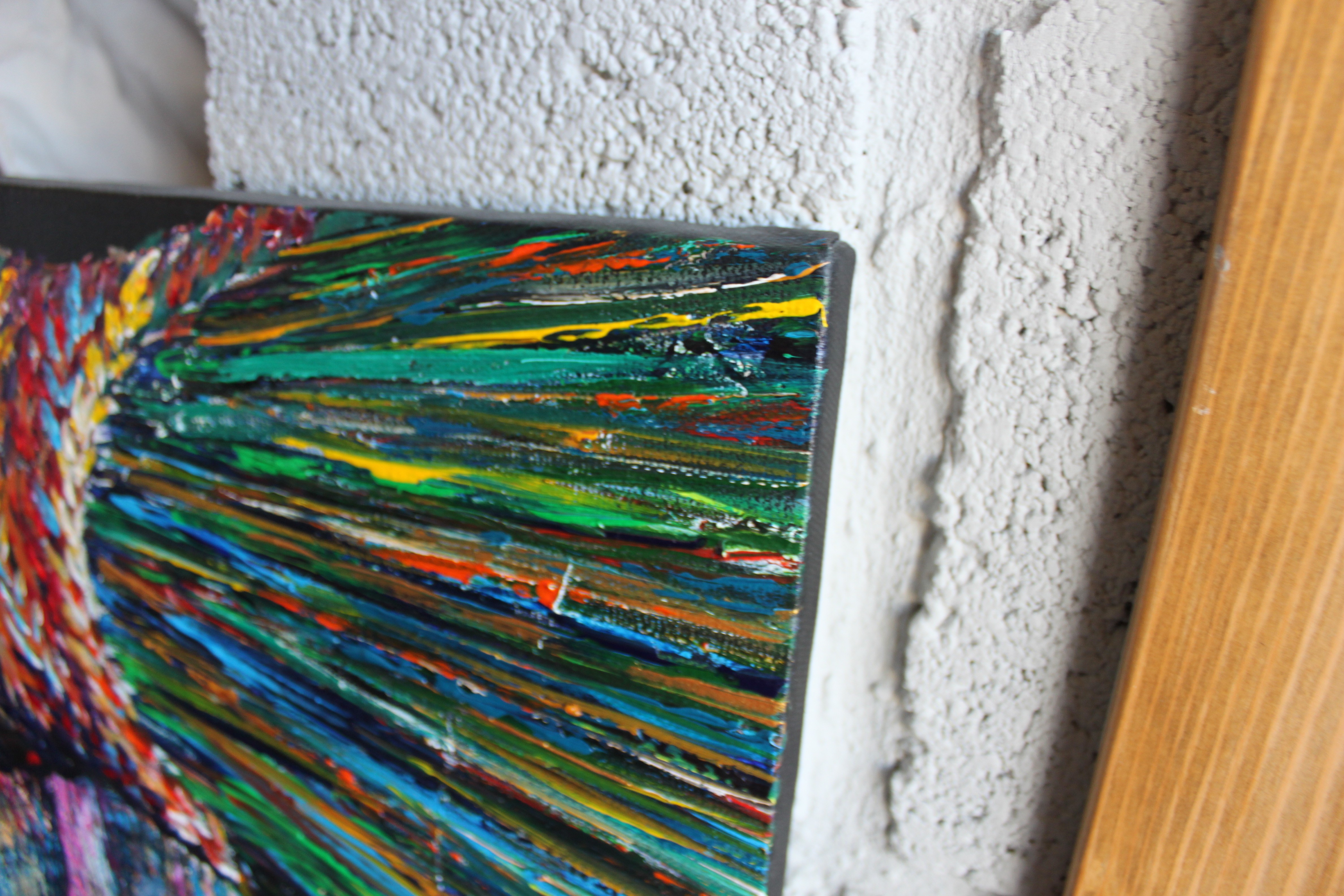 A painting of a woman with a colorful hat on a wall.