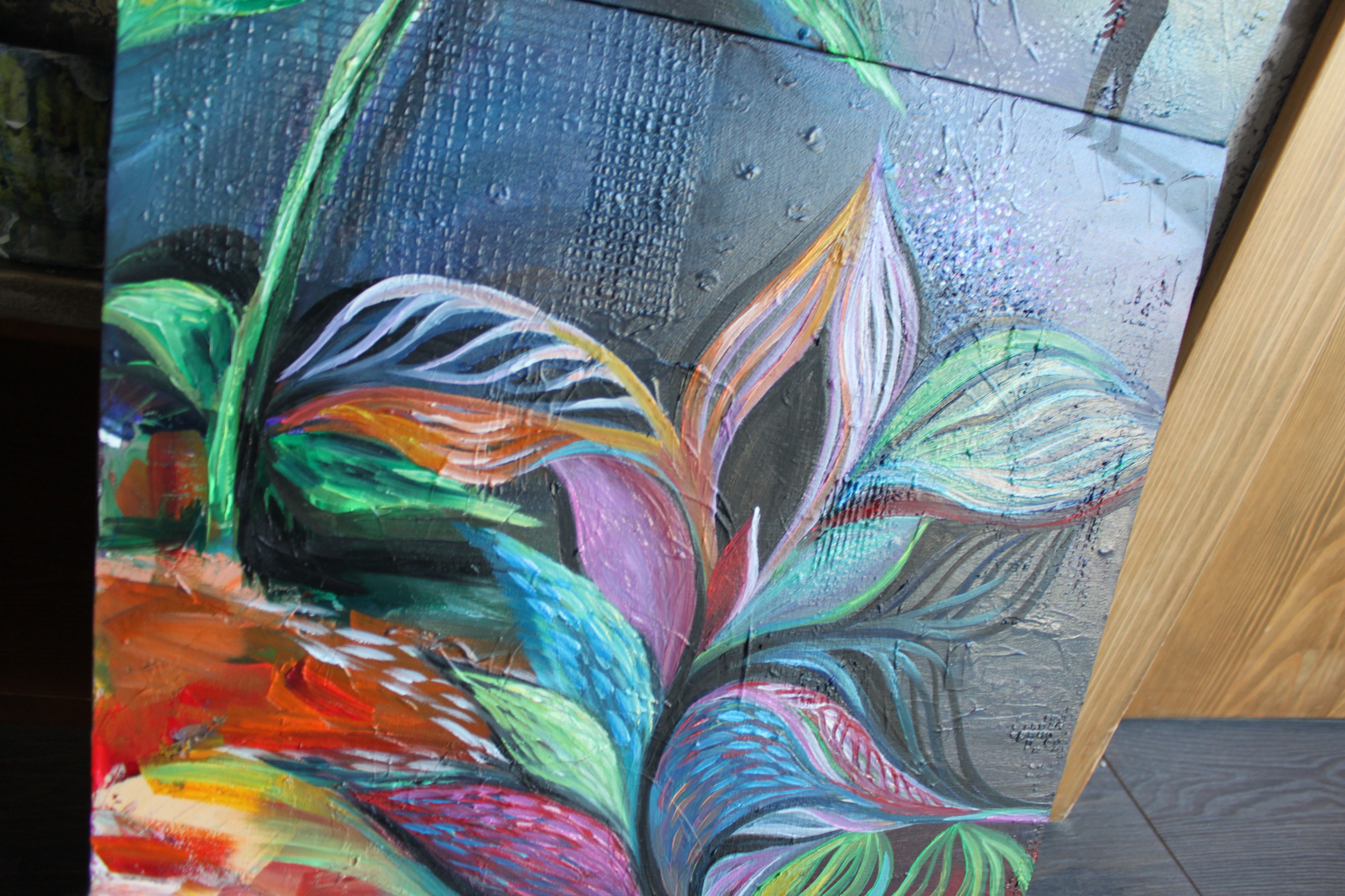 A painting of a flower on a canvas in a room.