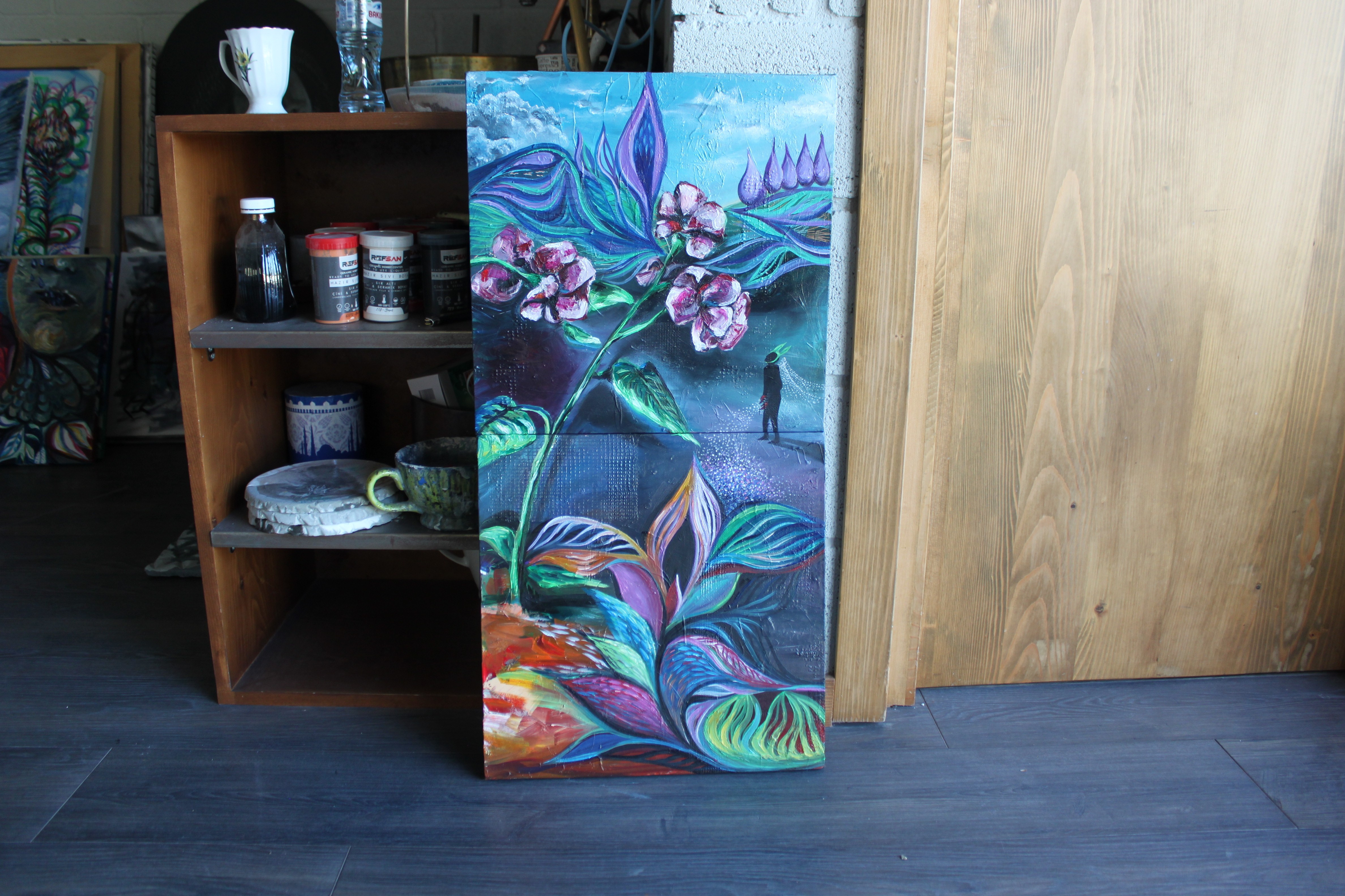 A painting of a flower on a canvas in a room.