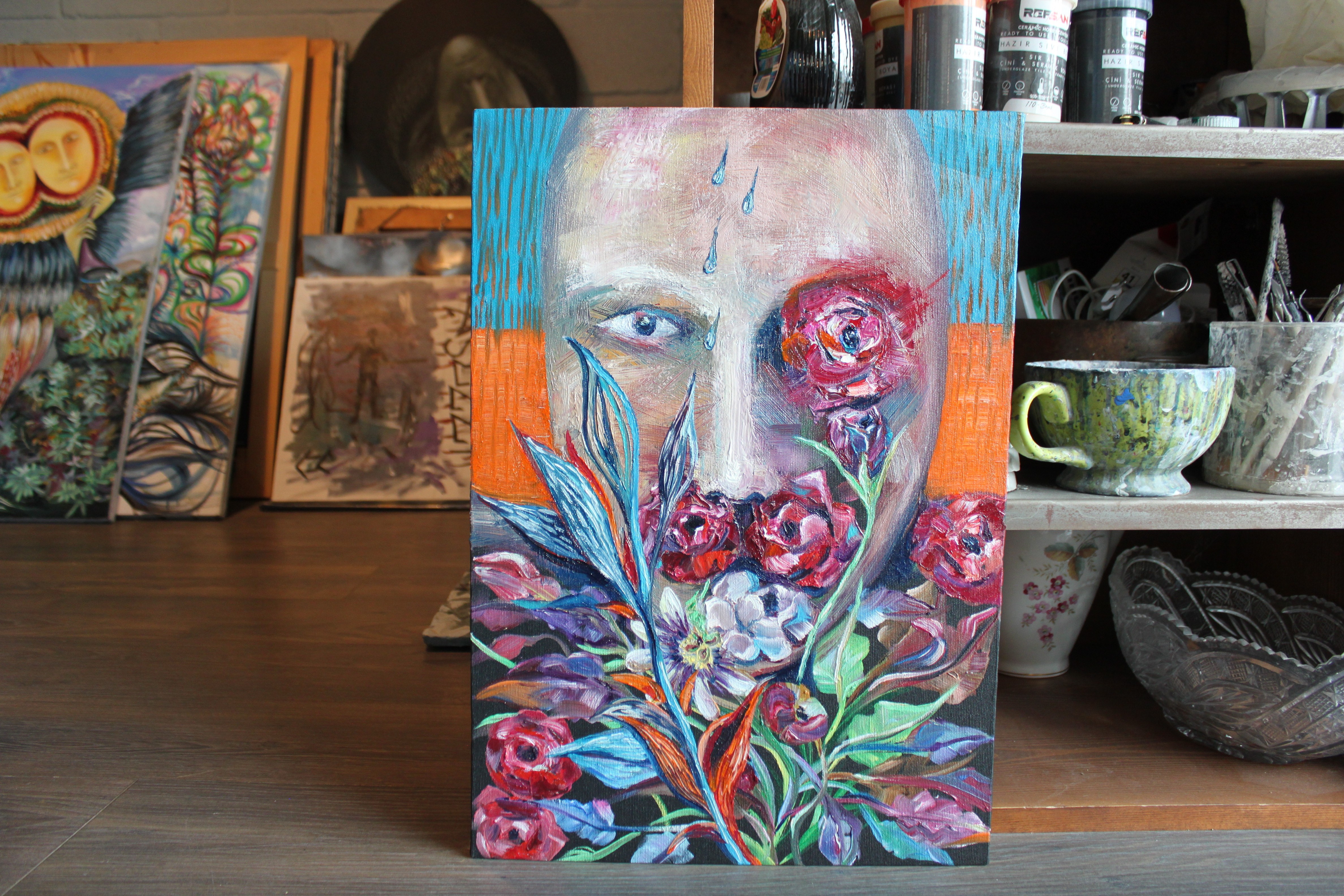 A painting of a woman's face on a wooden table.