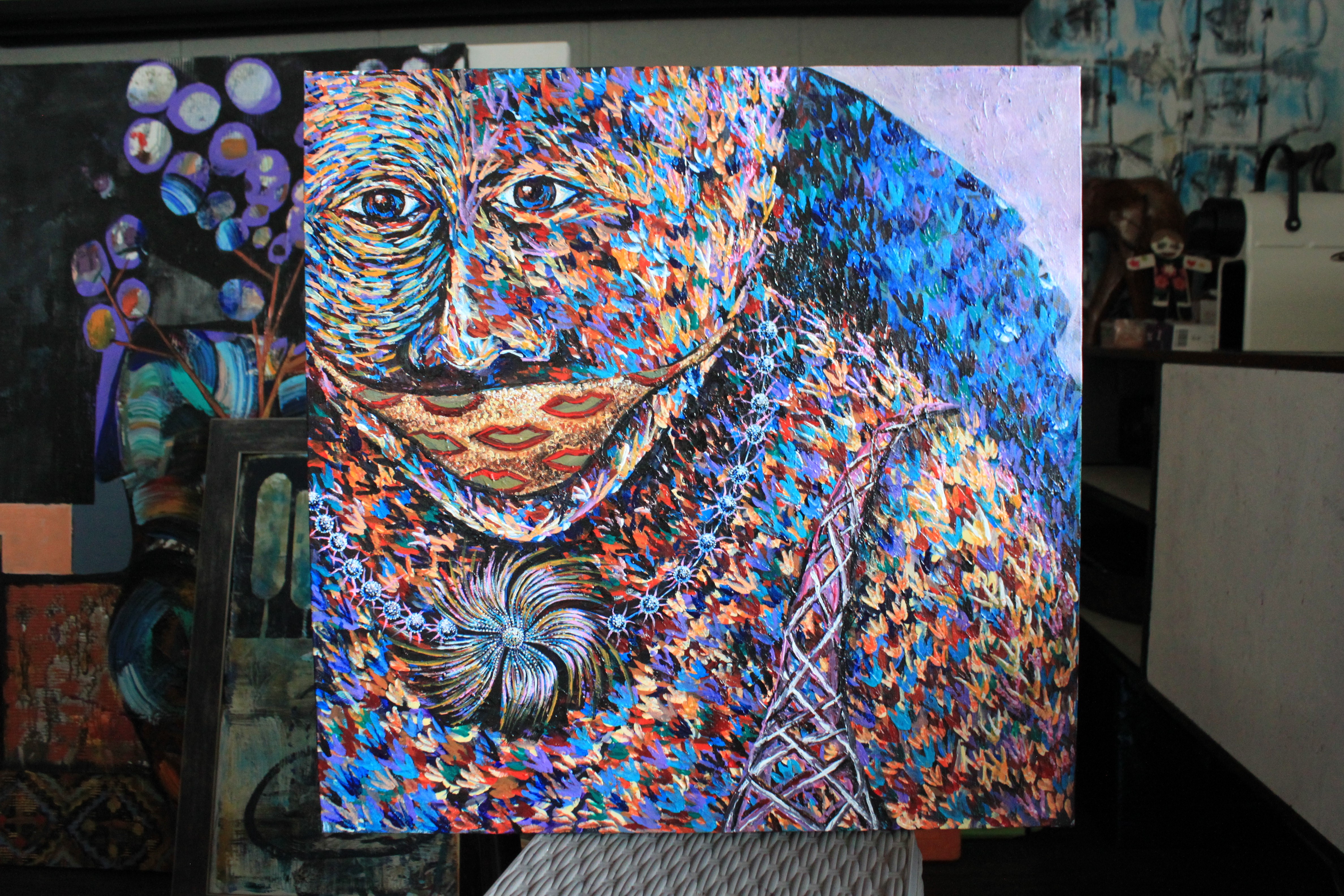 A painting of a woman's face on a canvas in a room.