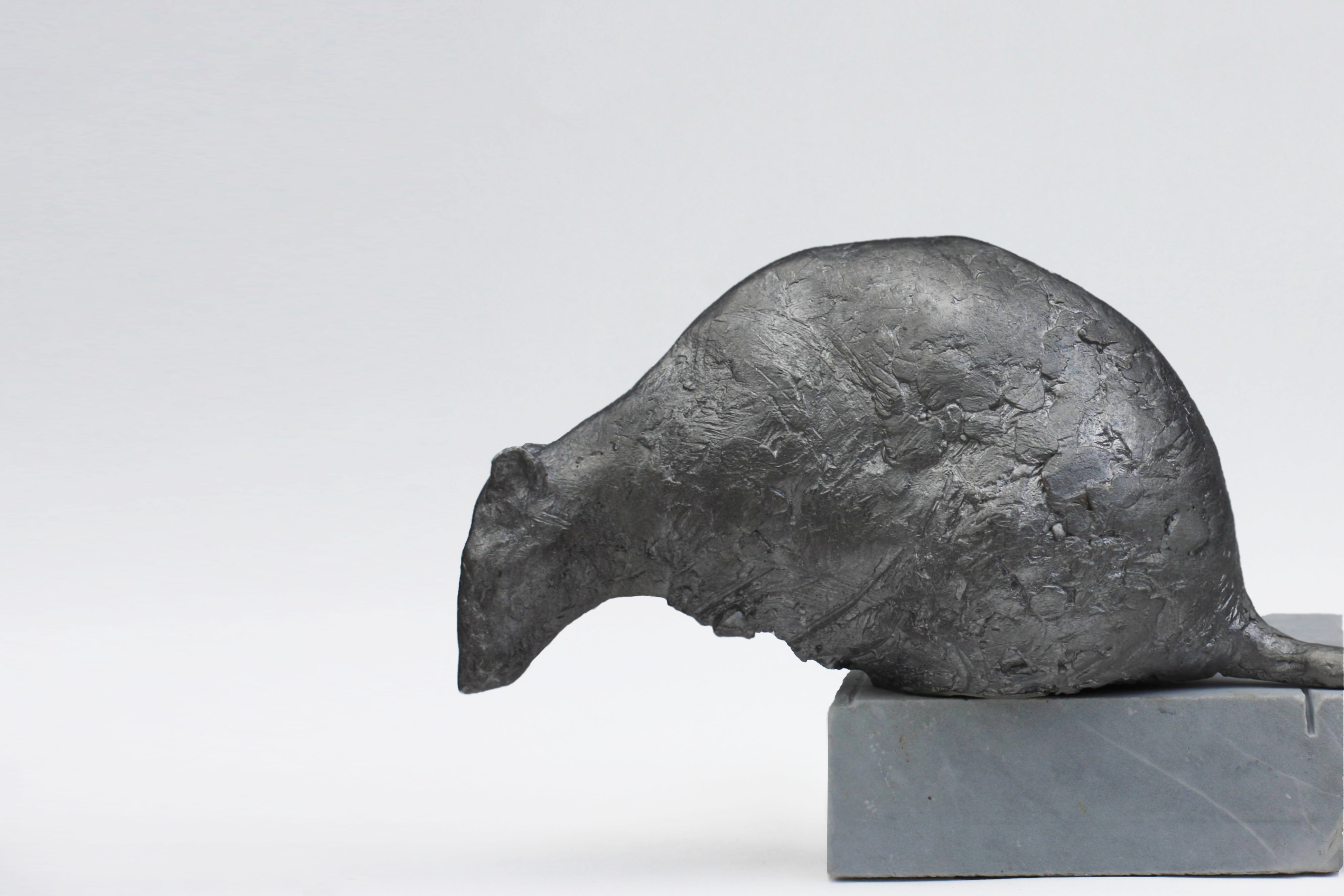 A sculpture of a rat on a marble base.