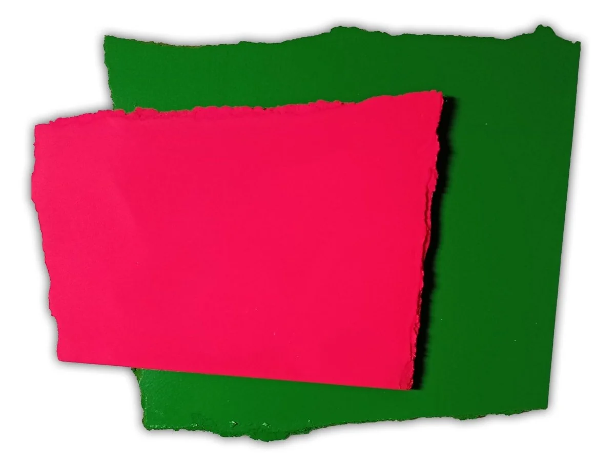 A layered composition of torn paper shapes in vivid pink and green against a white background.