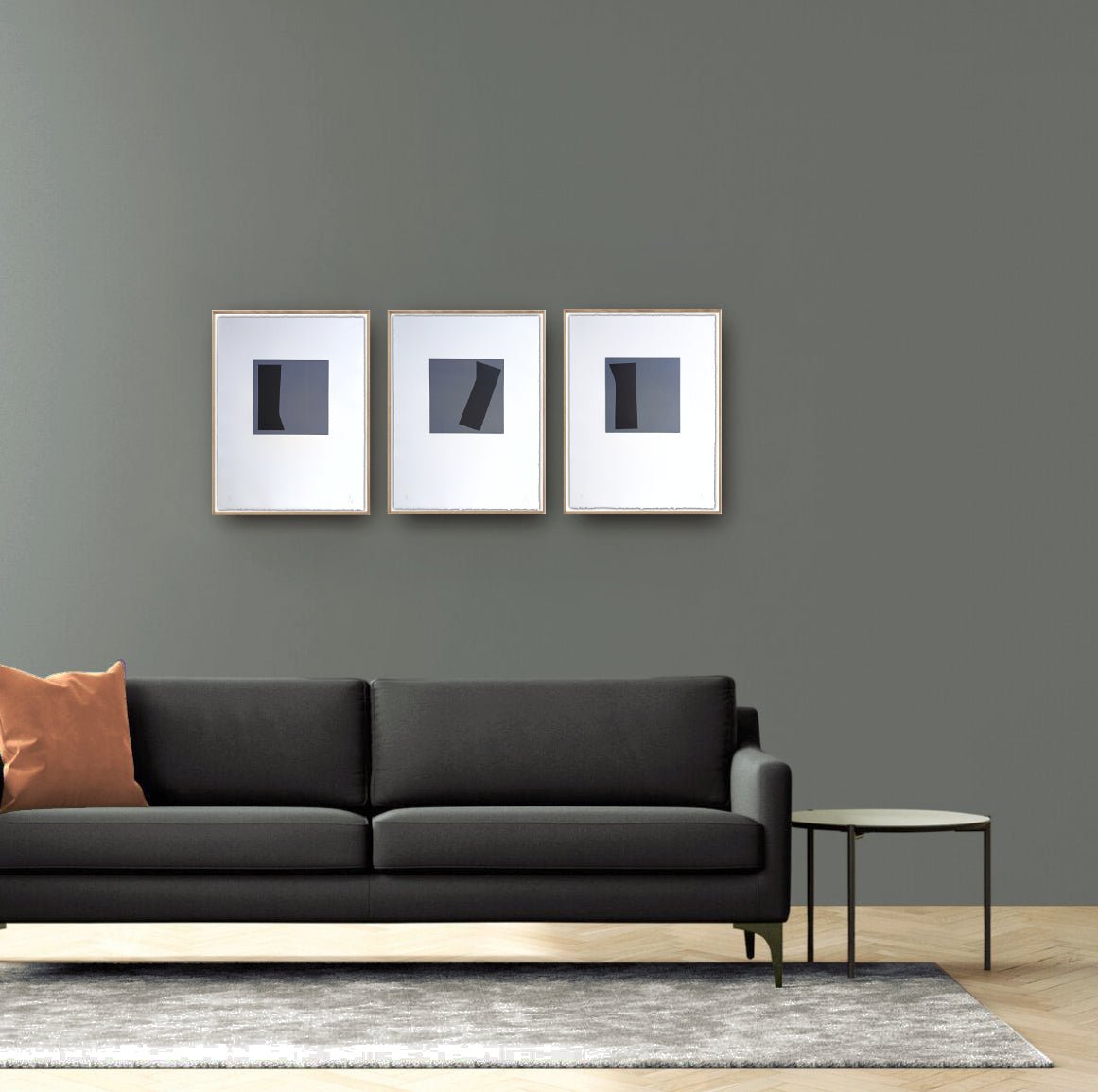 A triptych of minimalist abstract prints featuring dark geometric shapes on gray squares against white backgrounds.