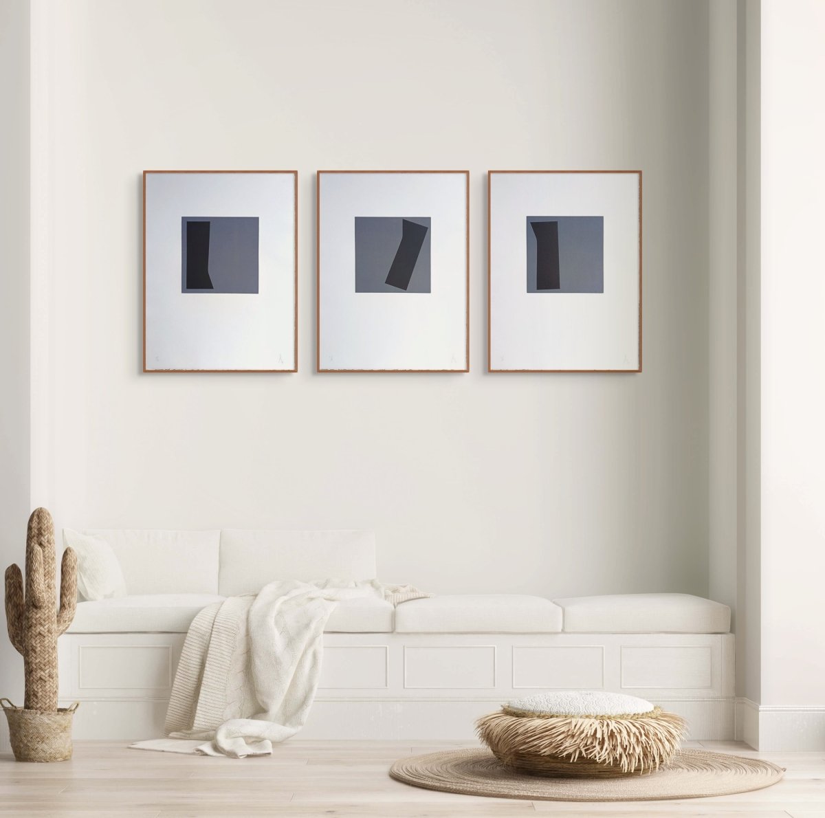 A triptych of minimalist abstract prints featuring dark geometric shapes on gray squares against white backgrounds.