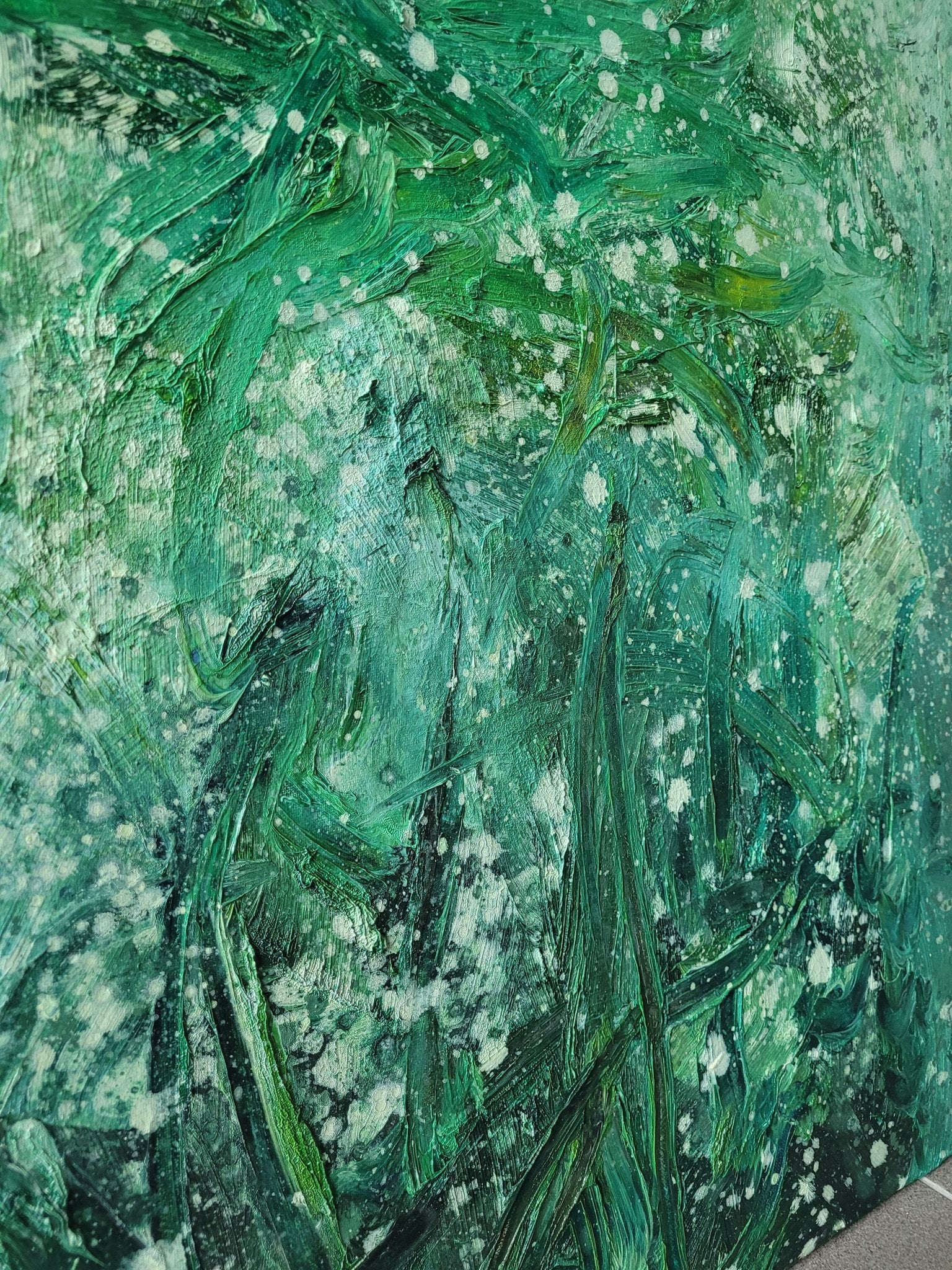 An abstract oil painting featuring a face formed by thick green brushstrokes and white splatters.