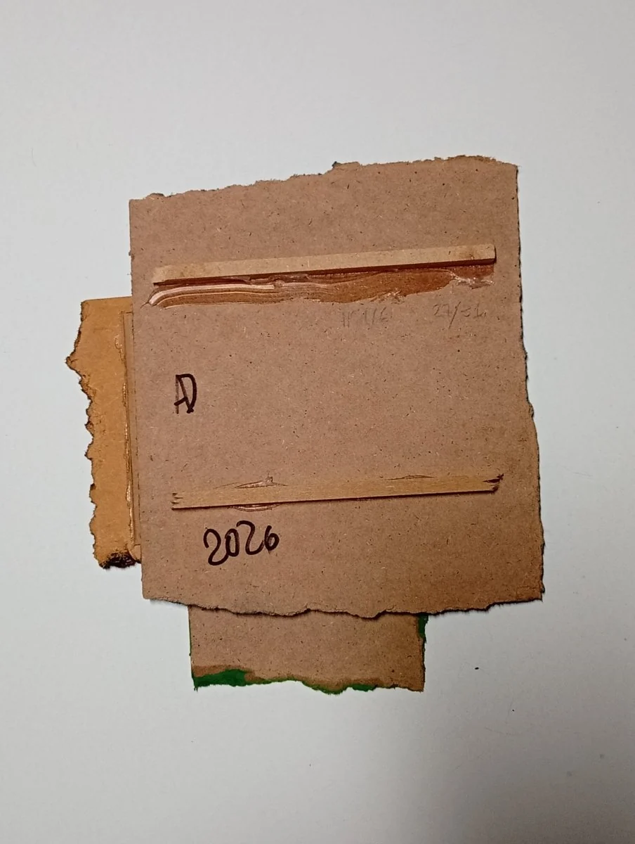 A layered composition of three rectangular paper sheets in blue, green, and pink against a white background.