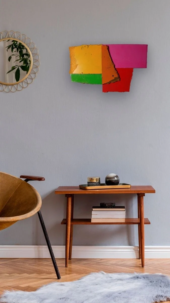 A colorful abstract composition of layered, torn rectangular shapes in primary and secondary colors.