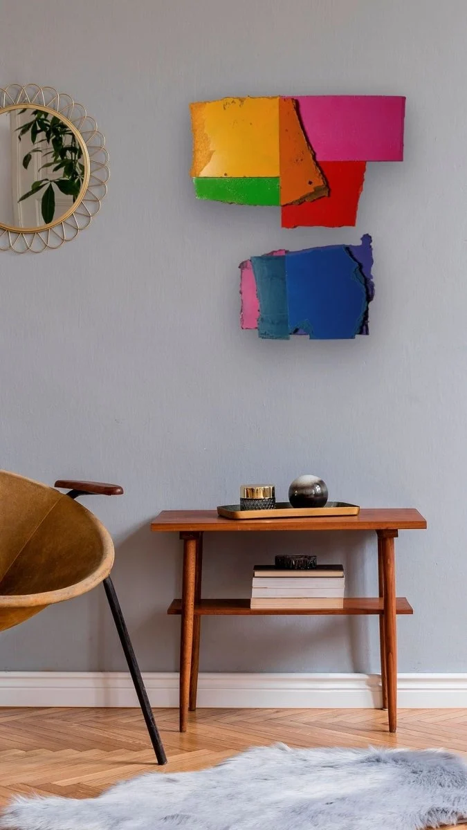 A colorful abstract composition of layered, torn rectangular shapes in primary and secondary colors.