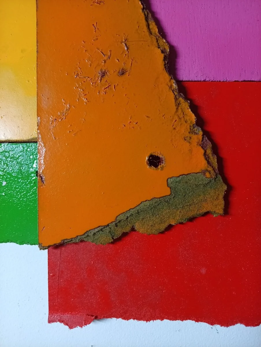 A colorful abstract composition of layered, torn rectangular shapes in primary and secondary colors.