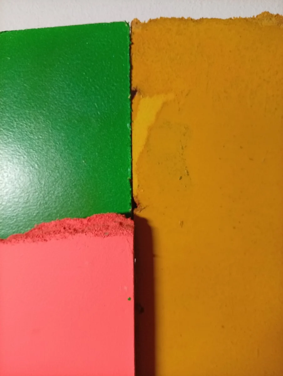 A colorful abstract composition of four painted paper fragments arranged in a grid.