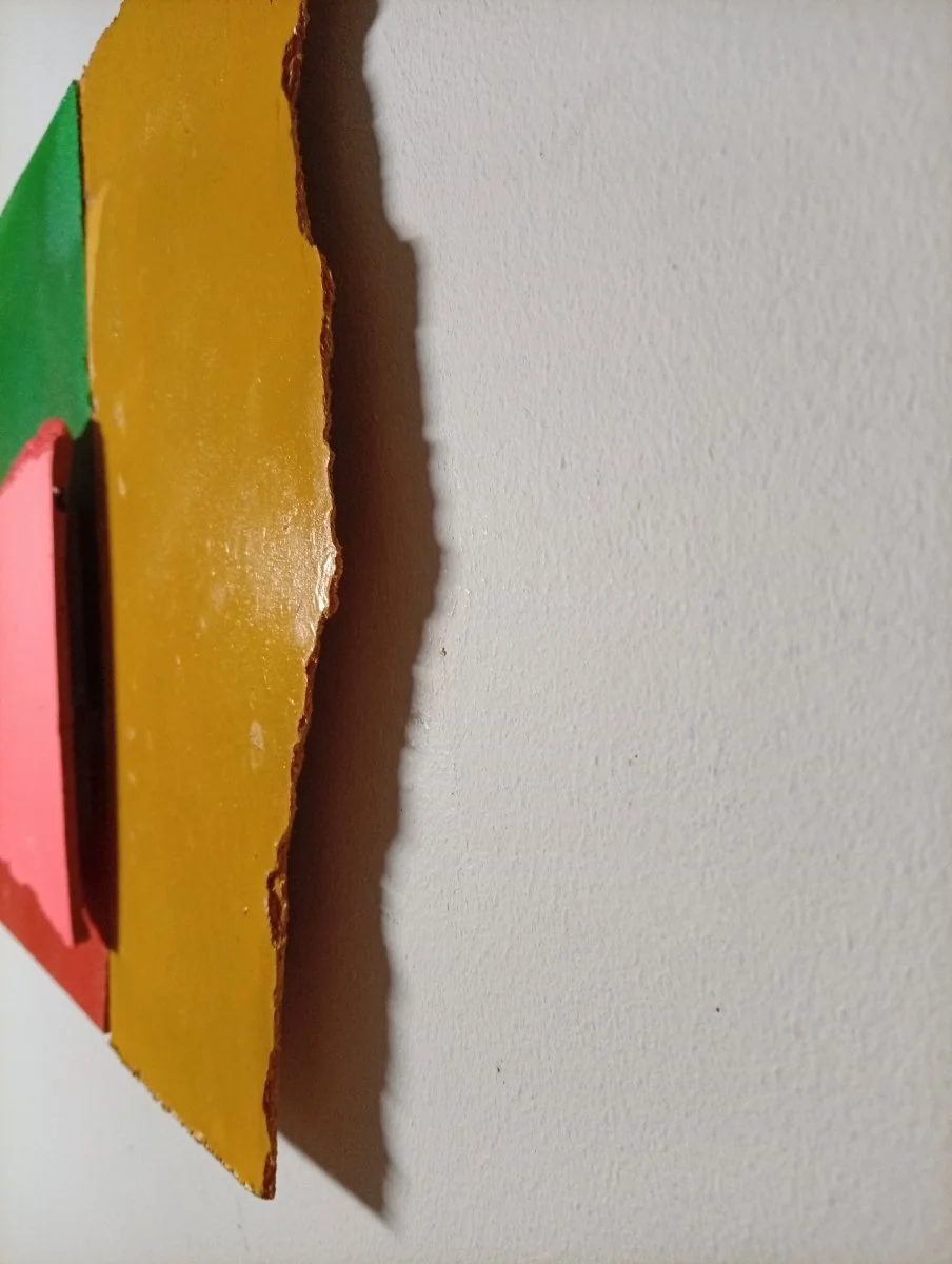 A colorful abstract composition of four painted paper fragments arranged in a grid.