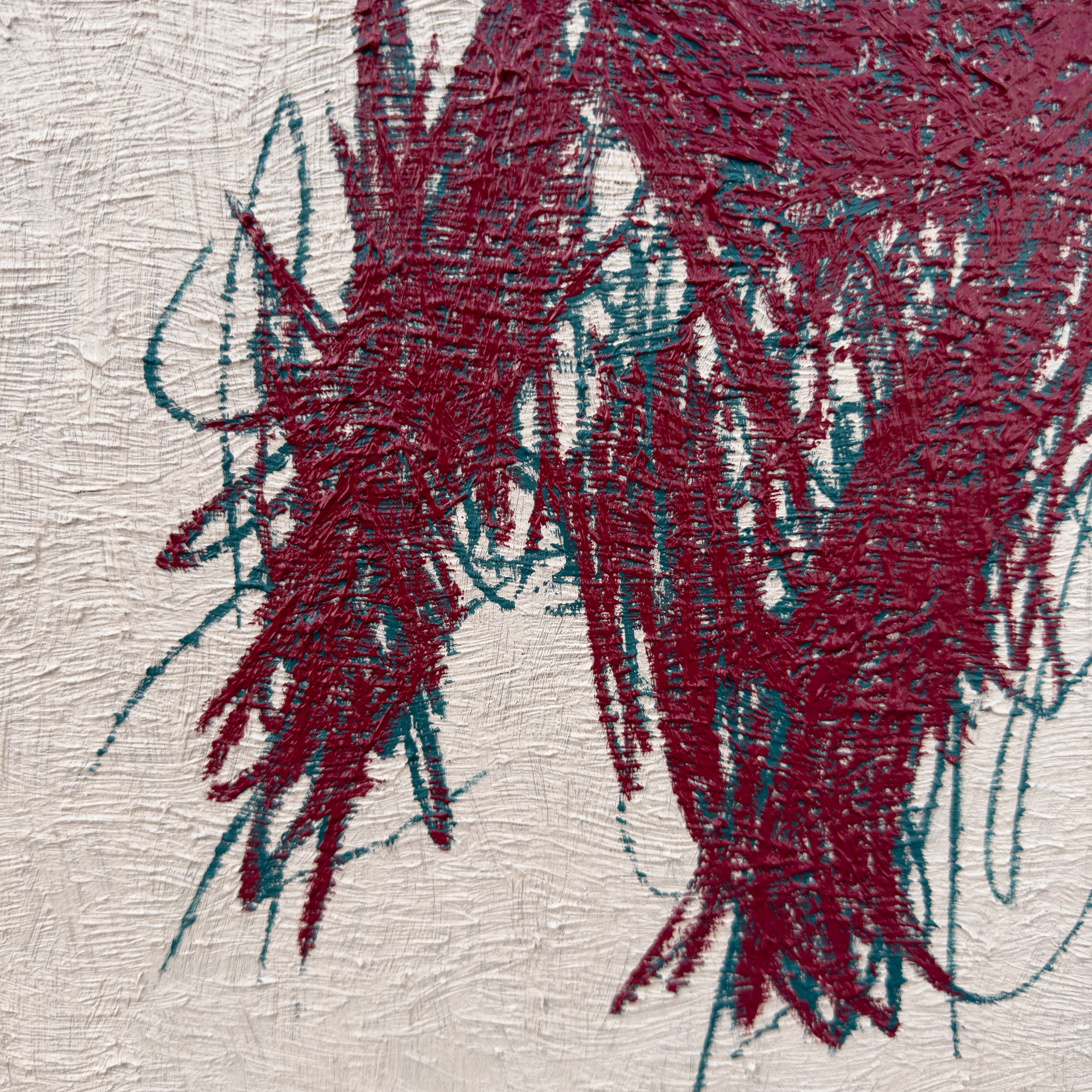 A close-up of a textured surface featuring bold, abstract brushstrokes in deep red and teal.