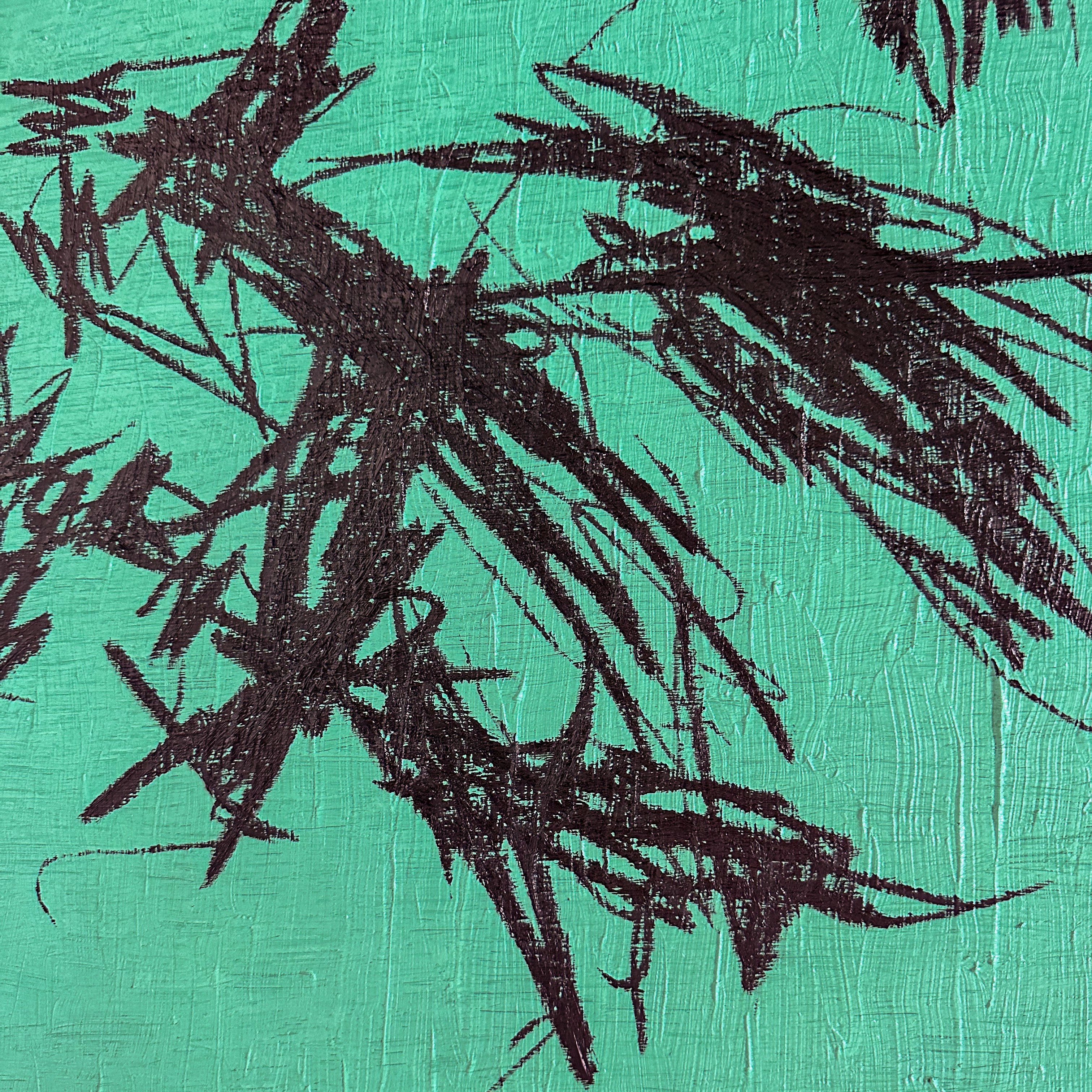 A close up of a painting with black paint on a green background.