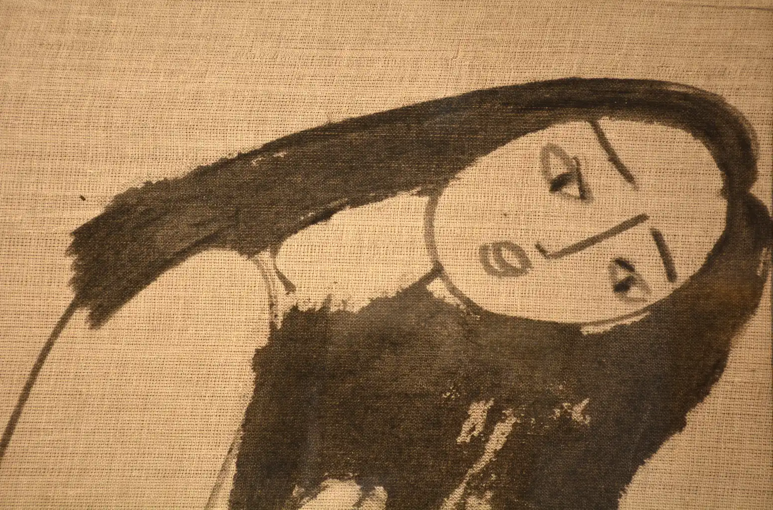 A black ink drawing of a crouching figure with long hair on textured beige paper.
