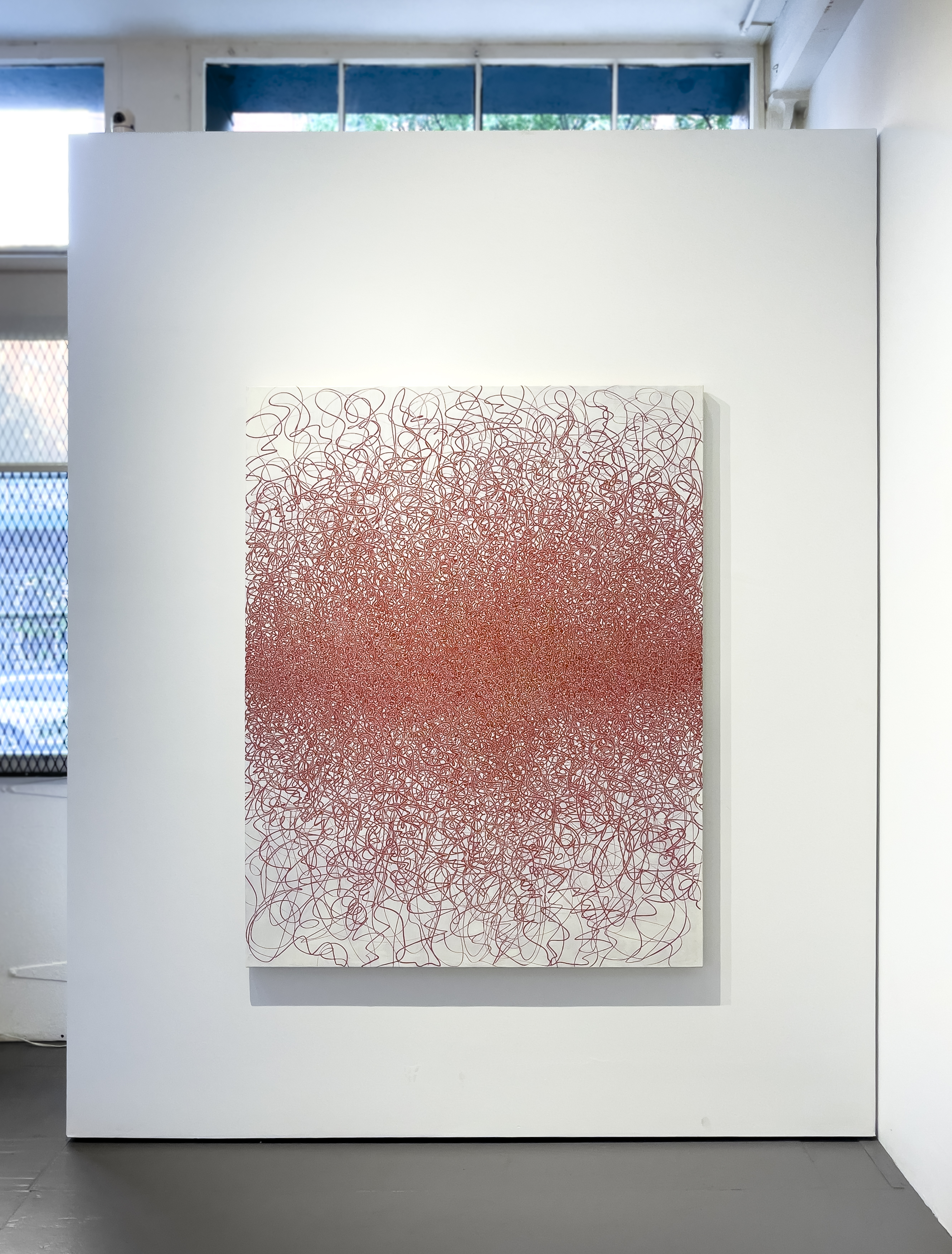 A dense abstract composition of tangled red lines forming a central mass against a white background.