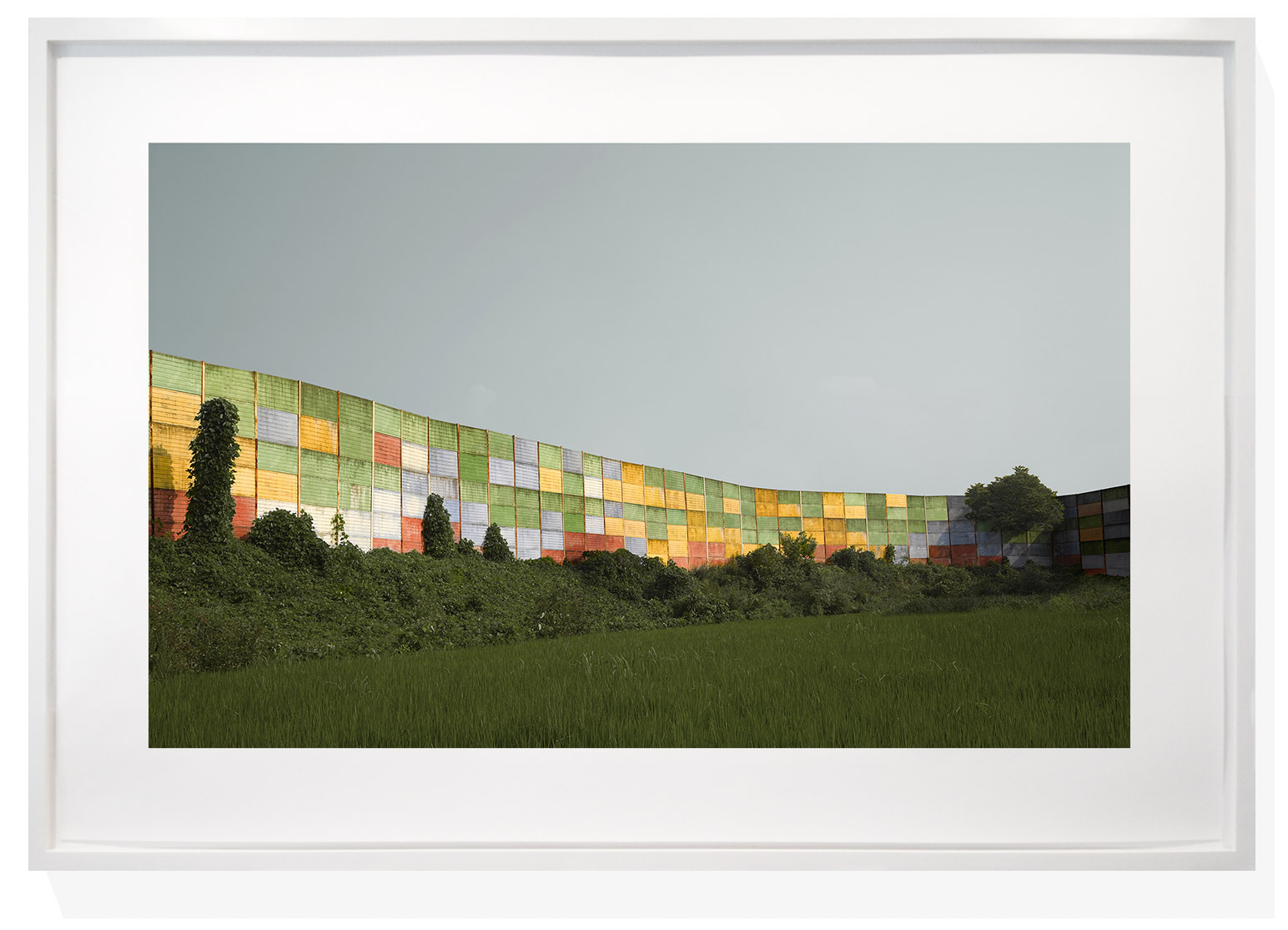 A vibrant, curved wall of stacked containers in a field.