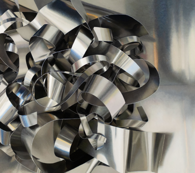 A chaotic sculpture of interwoven silver ribbons against a reflective metallic backdrop.