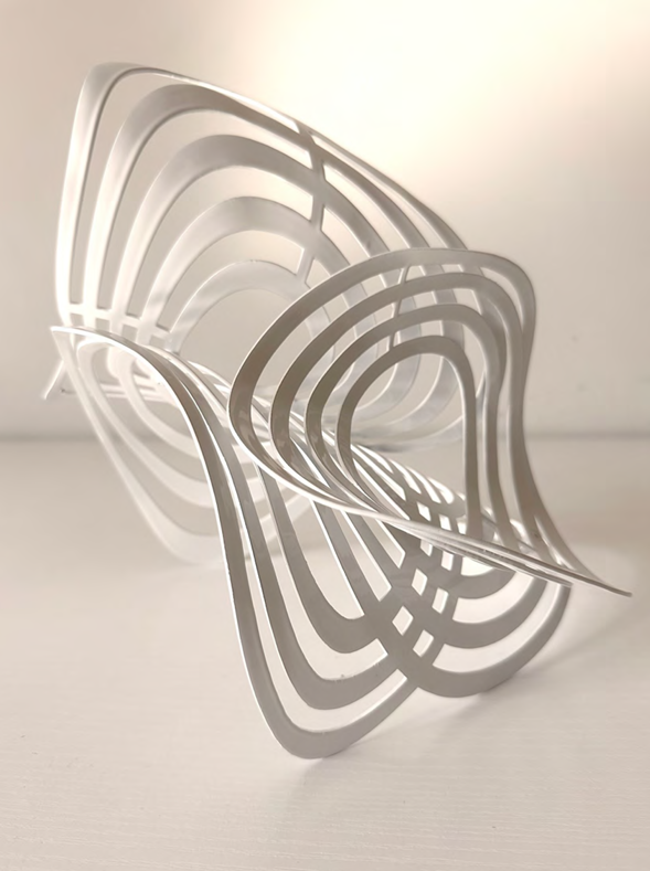 A sculptural piece of layered, curved white forms creating a dynamic, abstract composition.