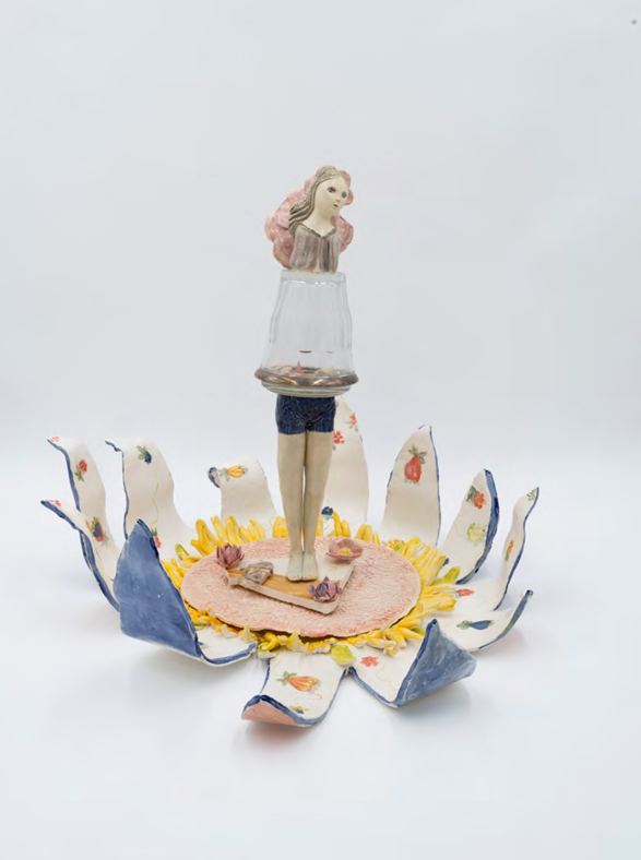 A surreal ceramic sculpture featuring a figure standing on a floral base with a glass vessel suspended above.