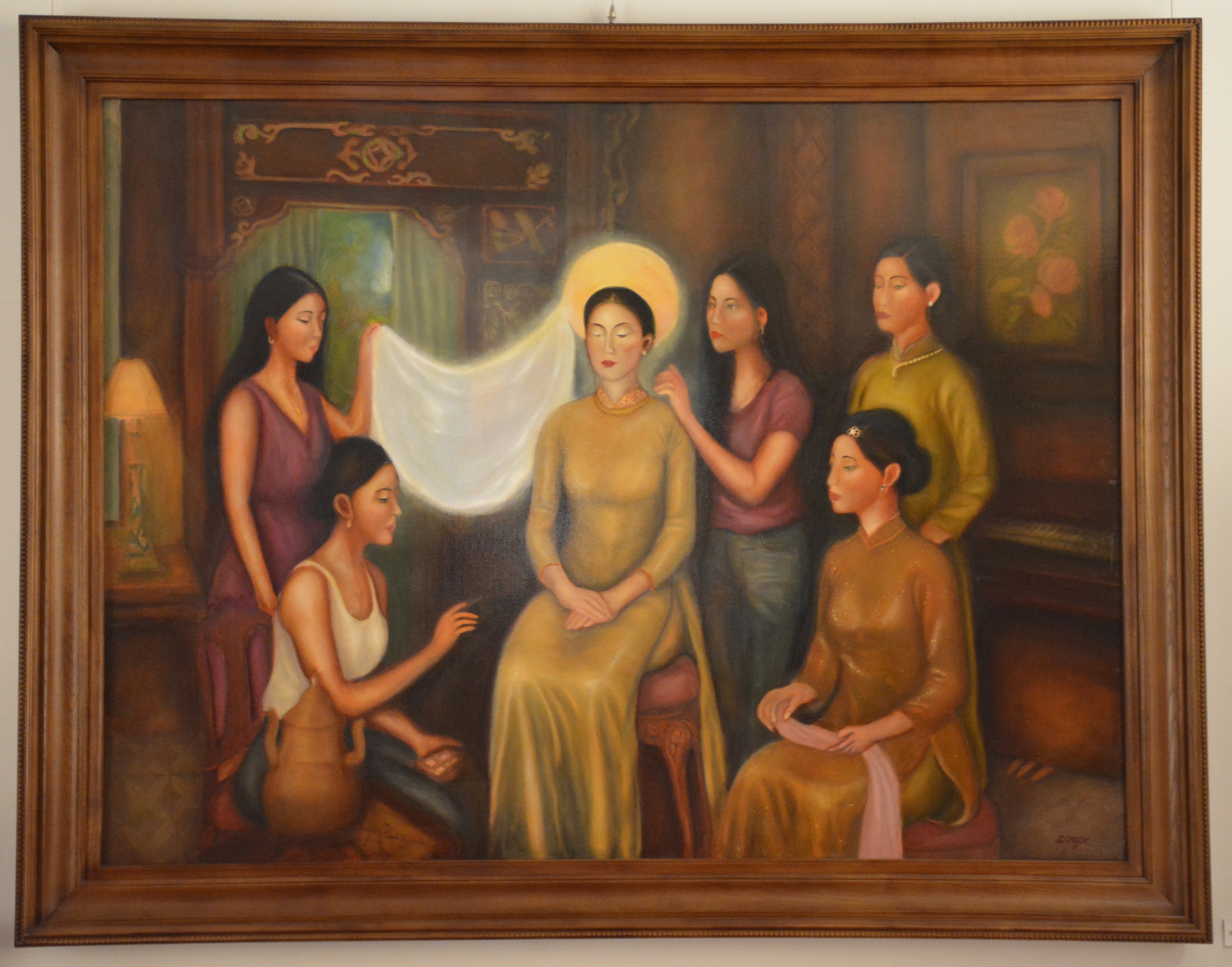 A group of figures in a warmly lit interior, centered on a seated woman with a radiant glow.