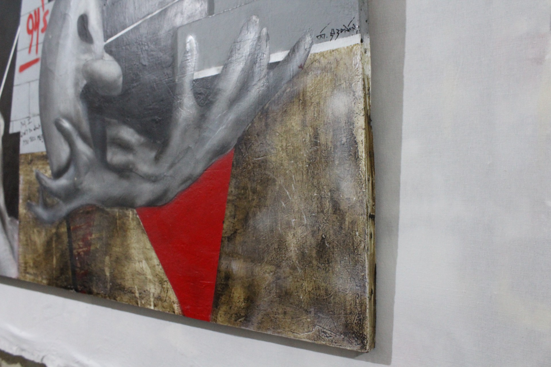 A painting of a hand on a wall with graffiti on it.