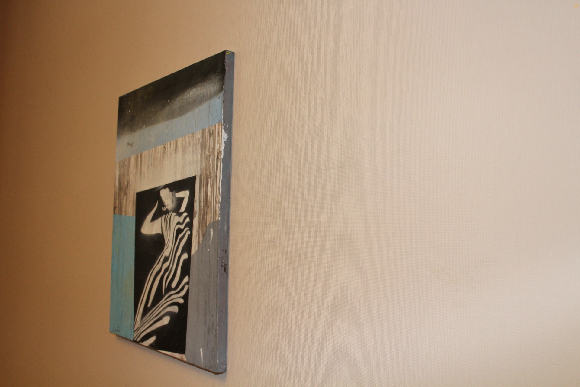 A vertical mixed-media artwork featuring a stylized figure against a textured, multi-toned background.