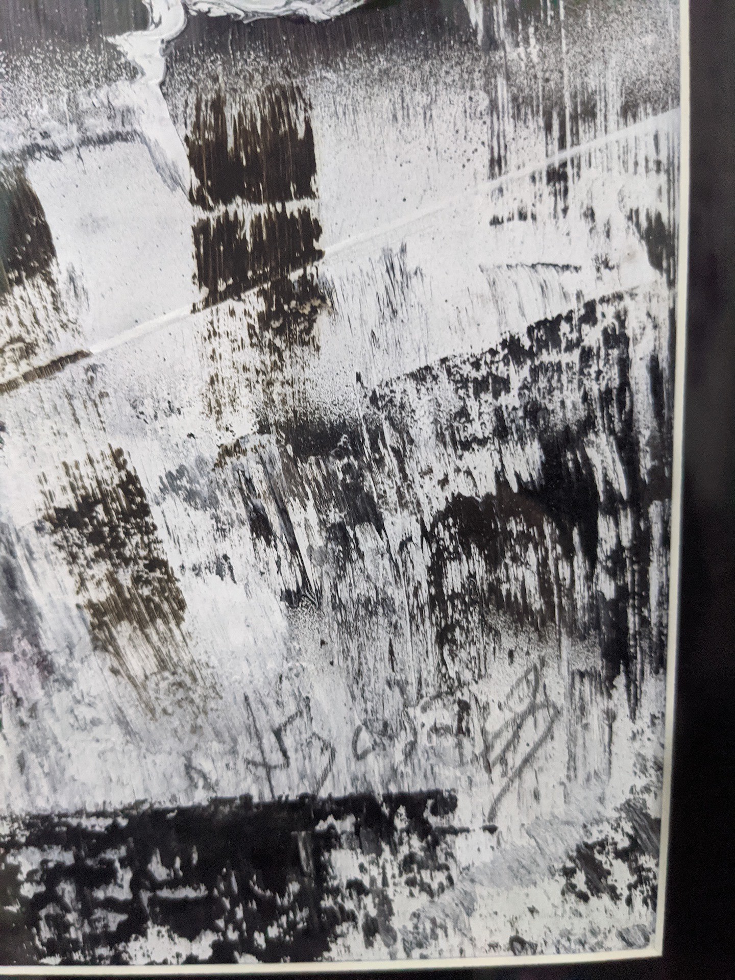 A black and white painting hanging on a wall.