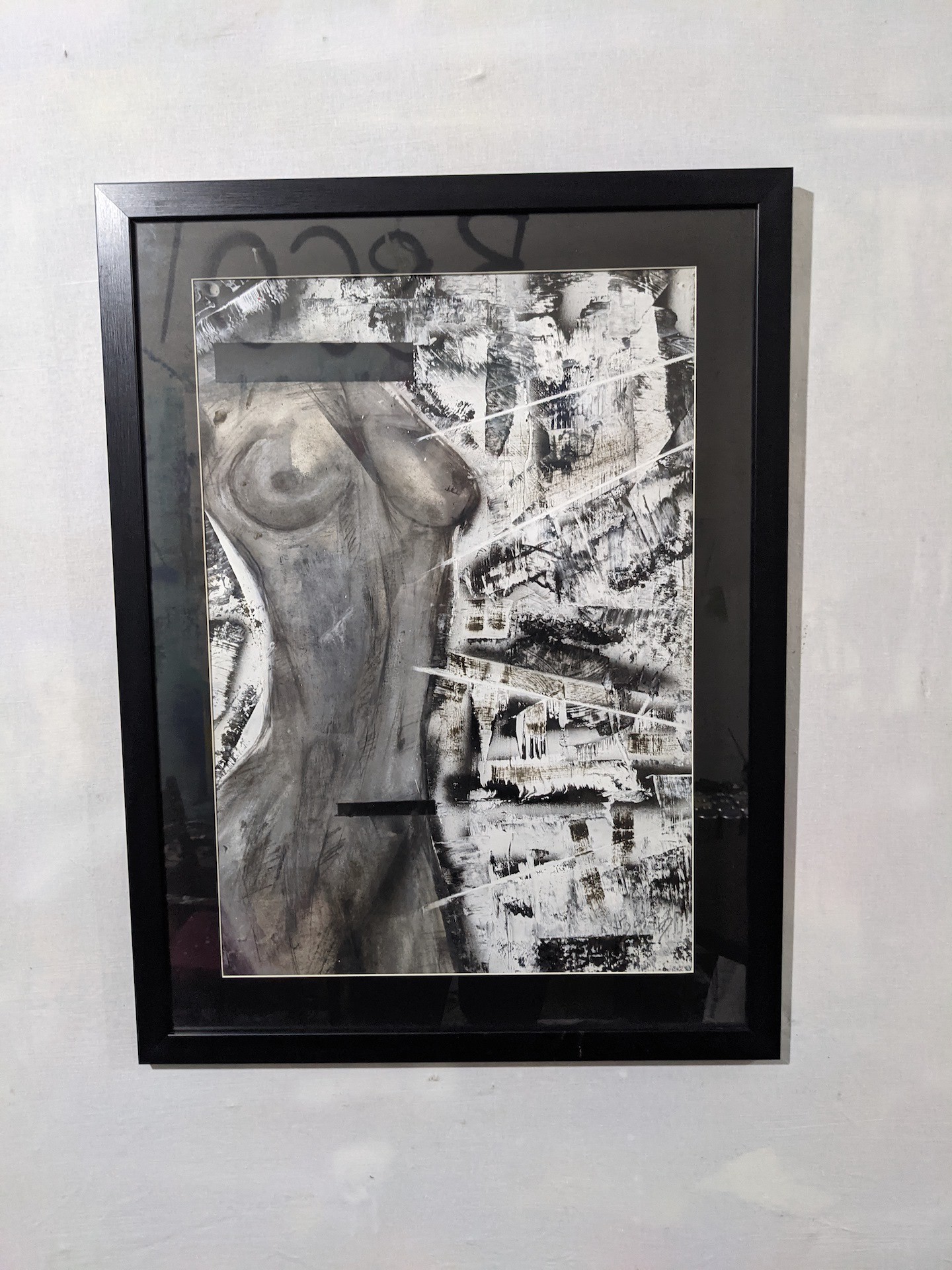 A black and white painting hanging on a wall.