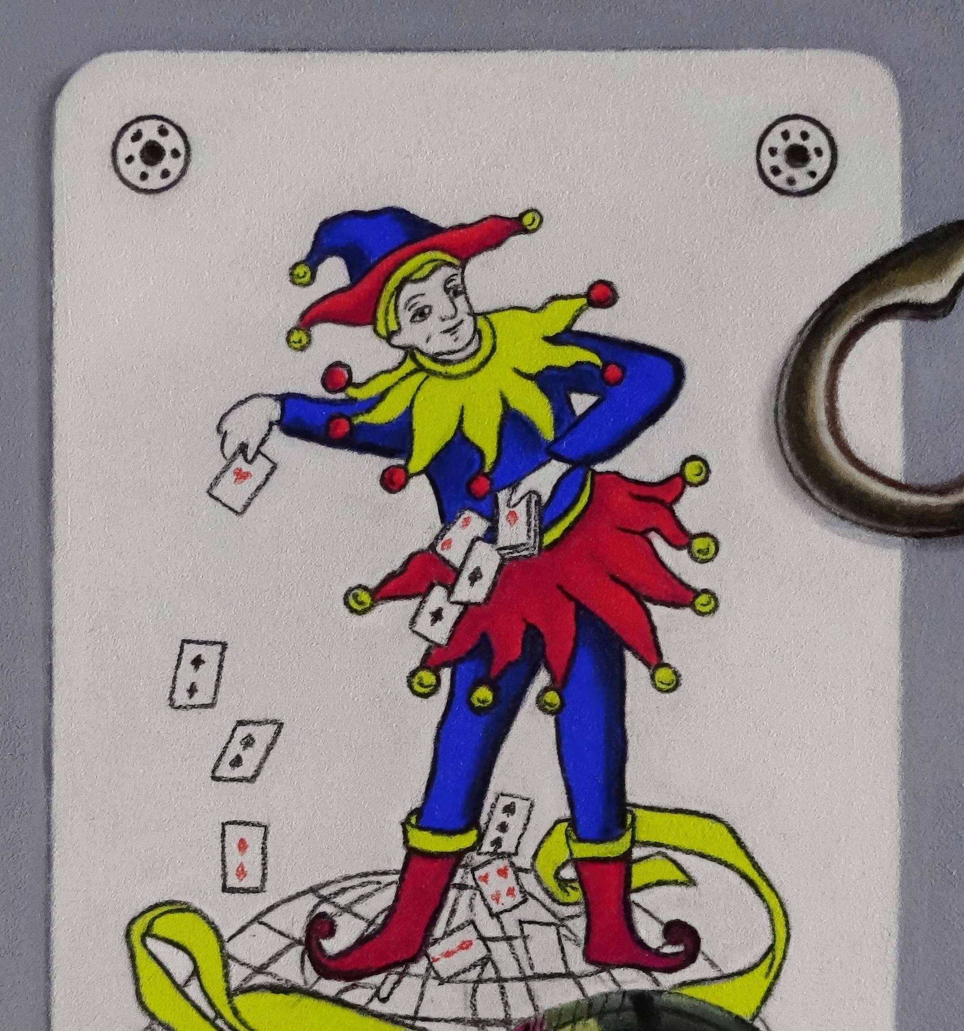 A drawing of a joker playing card next to a key and a glass ball.
