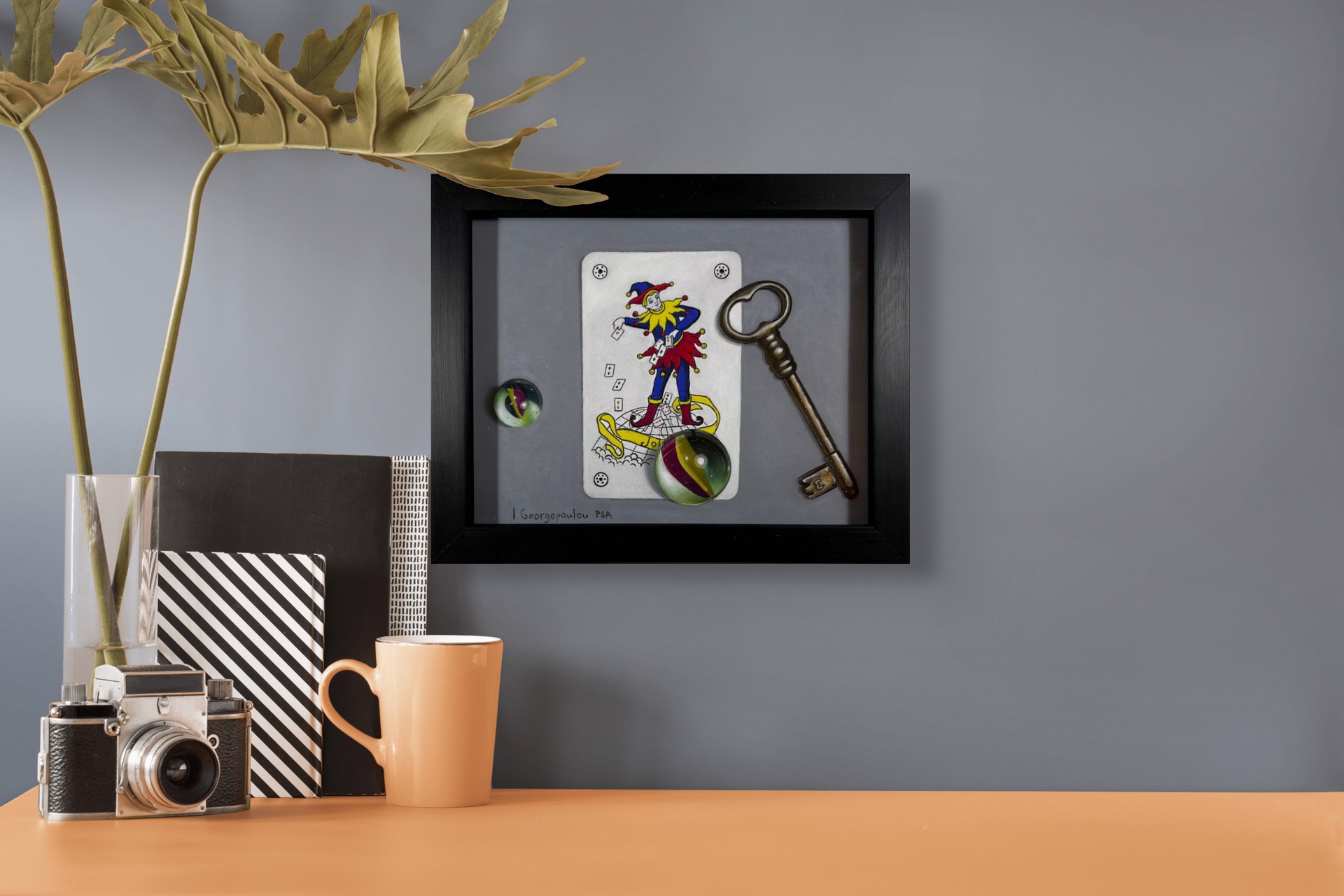 A drawing of a joker playing card next to a key and a glass ball.