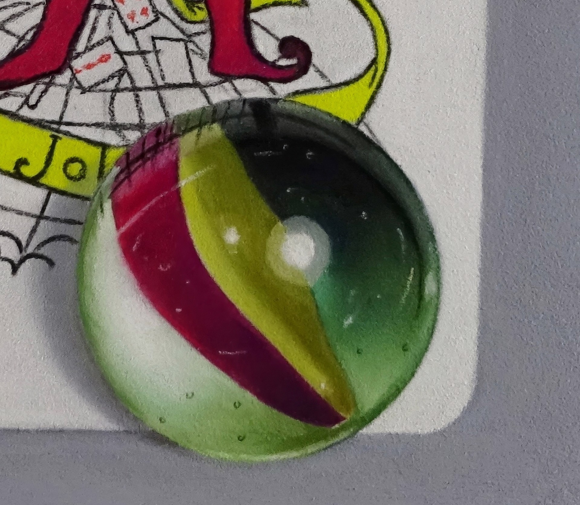 A drawing of a joker playing card next to a key and a glass ball.