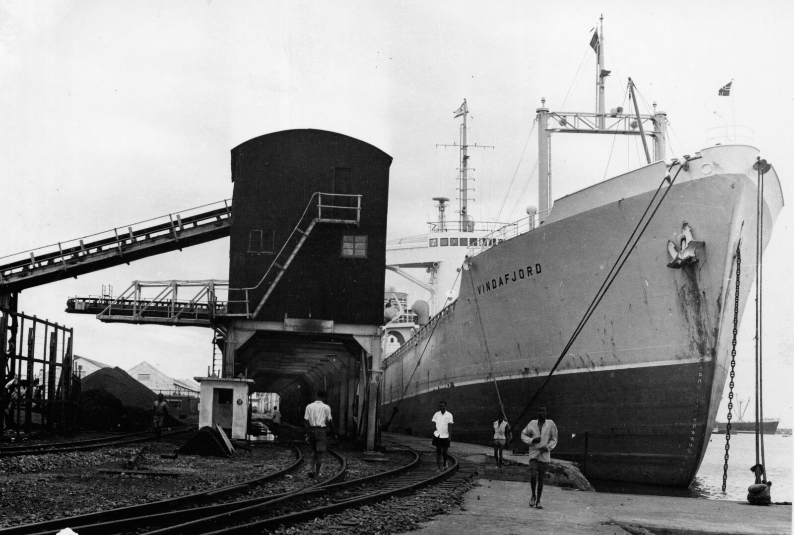 A ship loading bauxite at Takoradi Harbour by JK Bruce-Vanderpuije, 1958