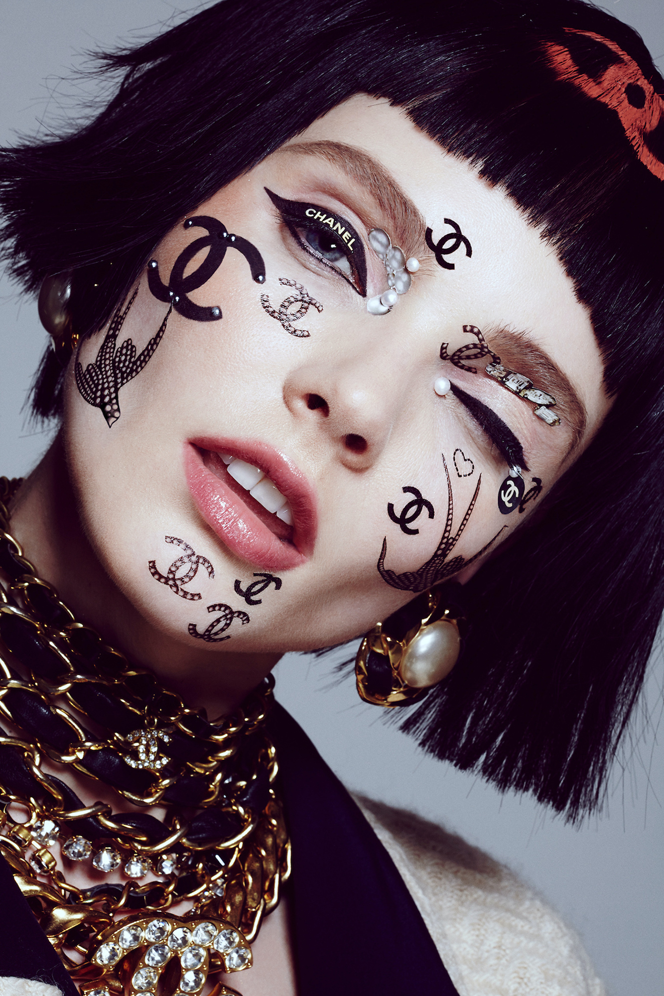 A woman with black hair and a chanel face paint.