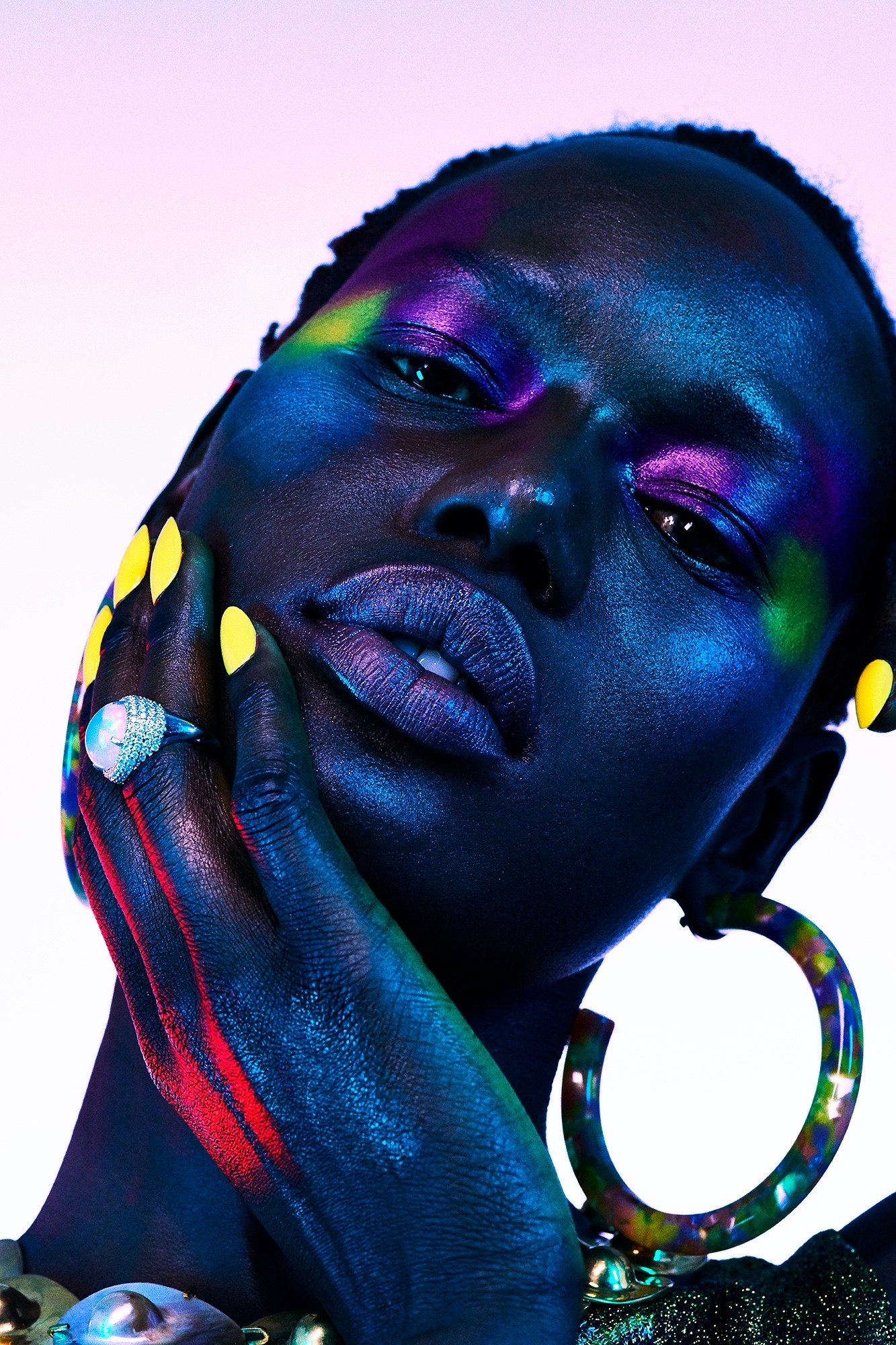 A woman with bright makeup and colorful nails.