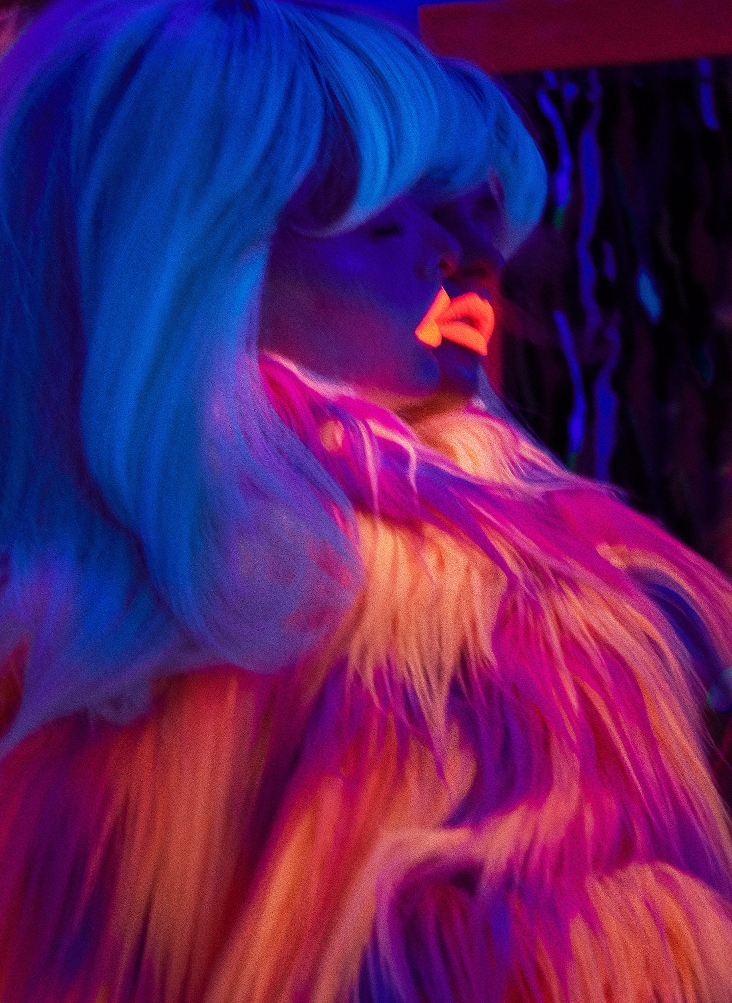 A woman with blue hair and a pink lipstick.