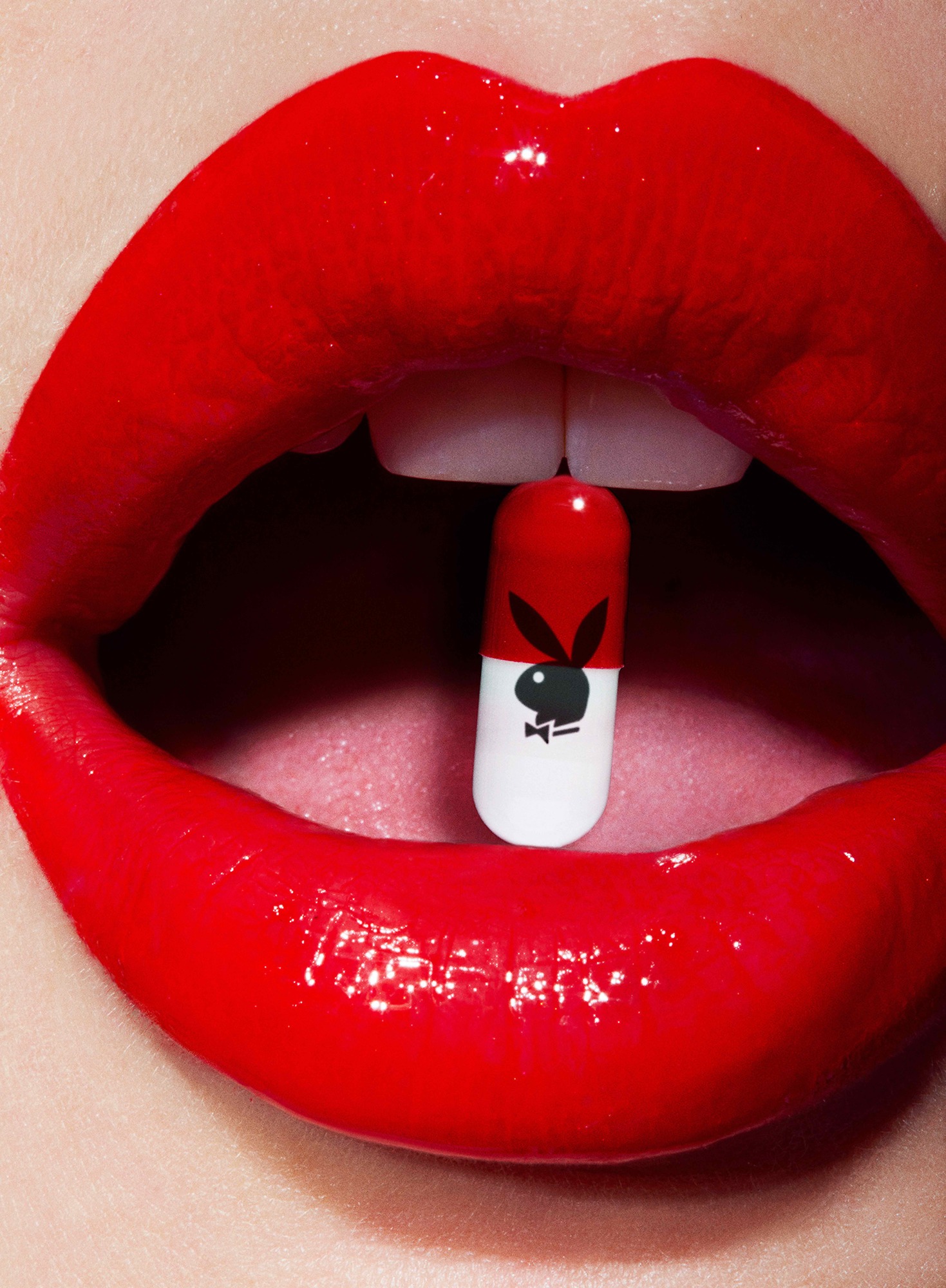 A close up of a woman's mouth with a pill in her mouth.