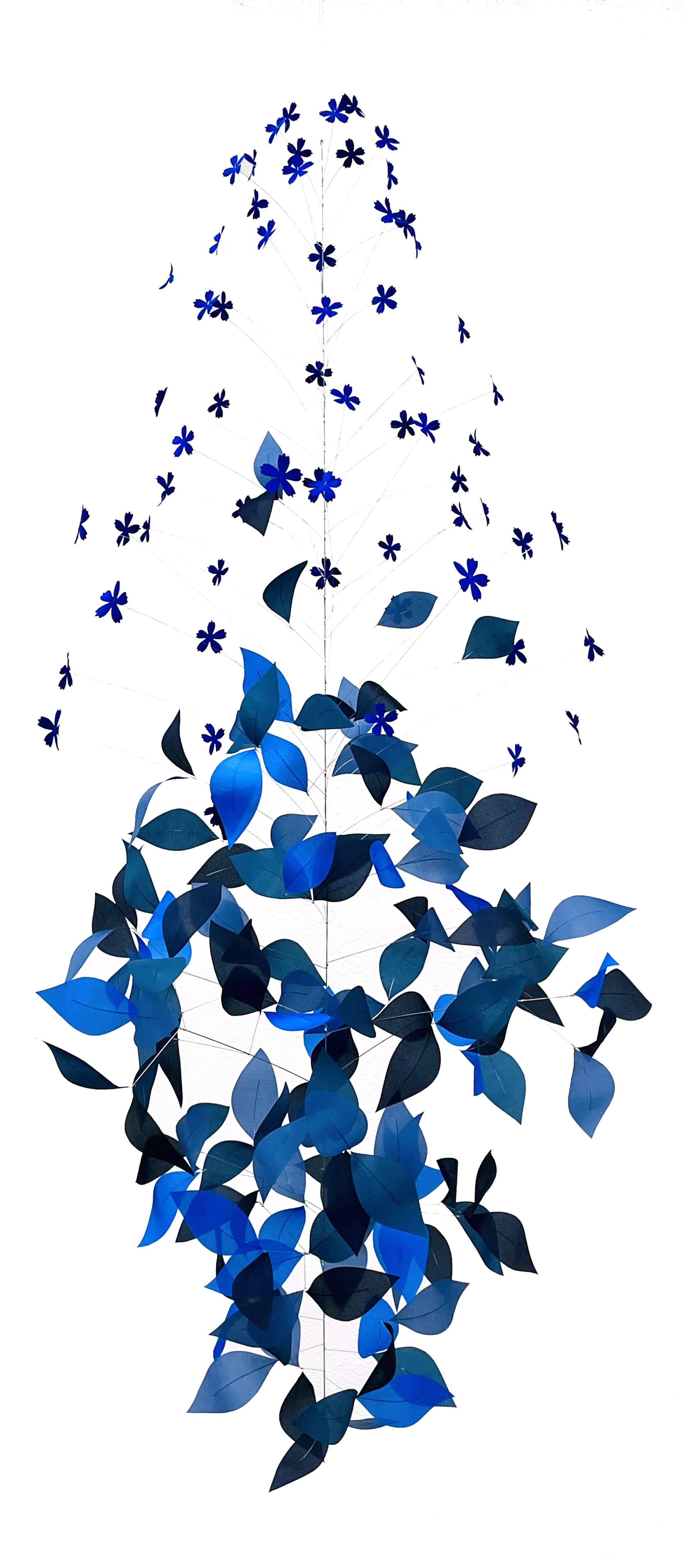 A vertical mobile sculpture featuring cascading blue leaves and star-shaped cutouts against a stark white background.