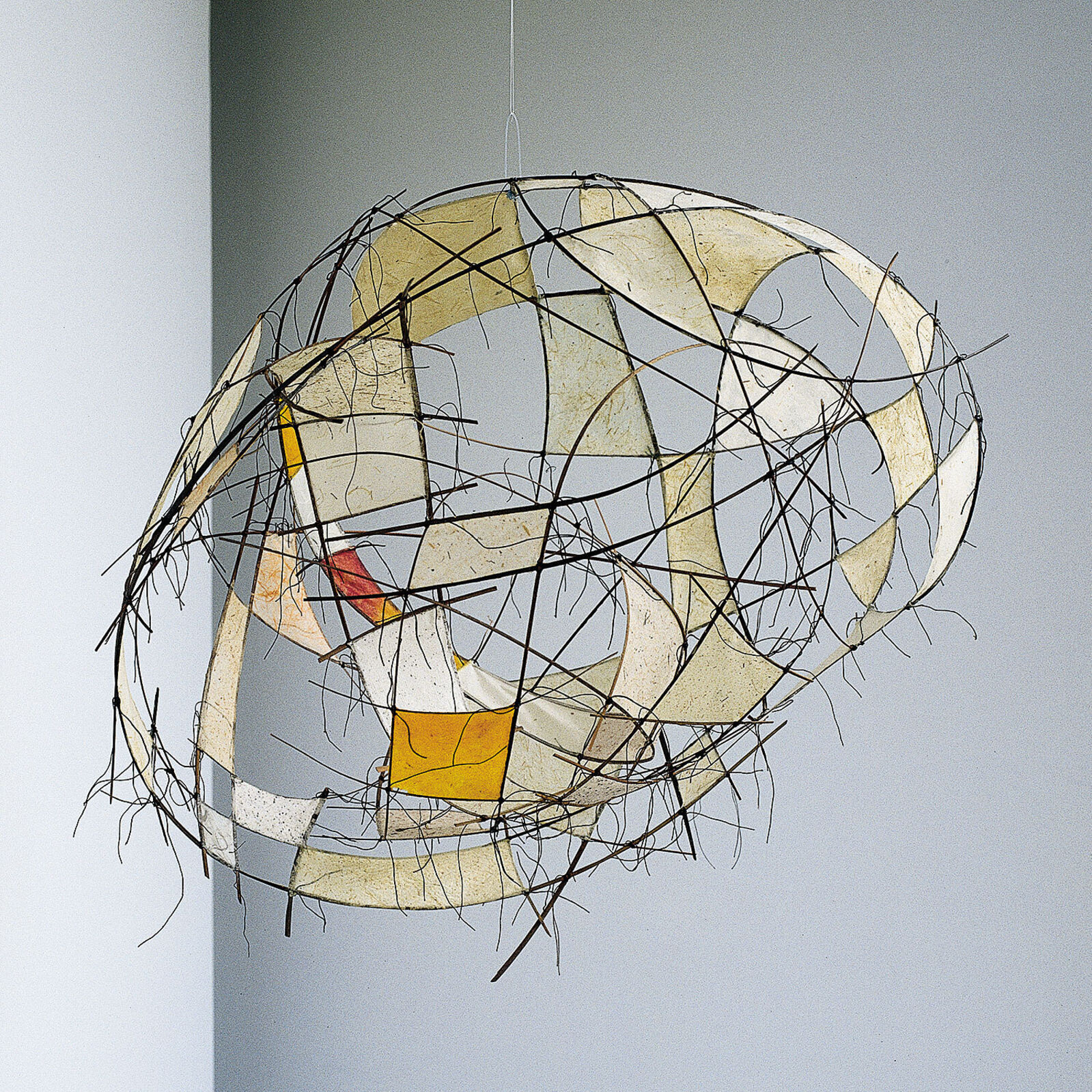 A suspended wire sculpture featuring translucent panels and abstract geometric forms.