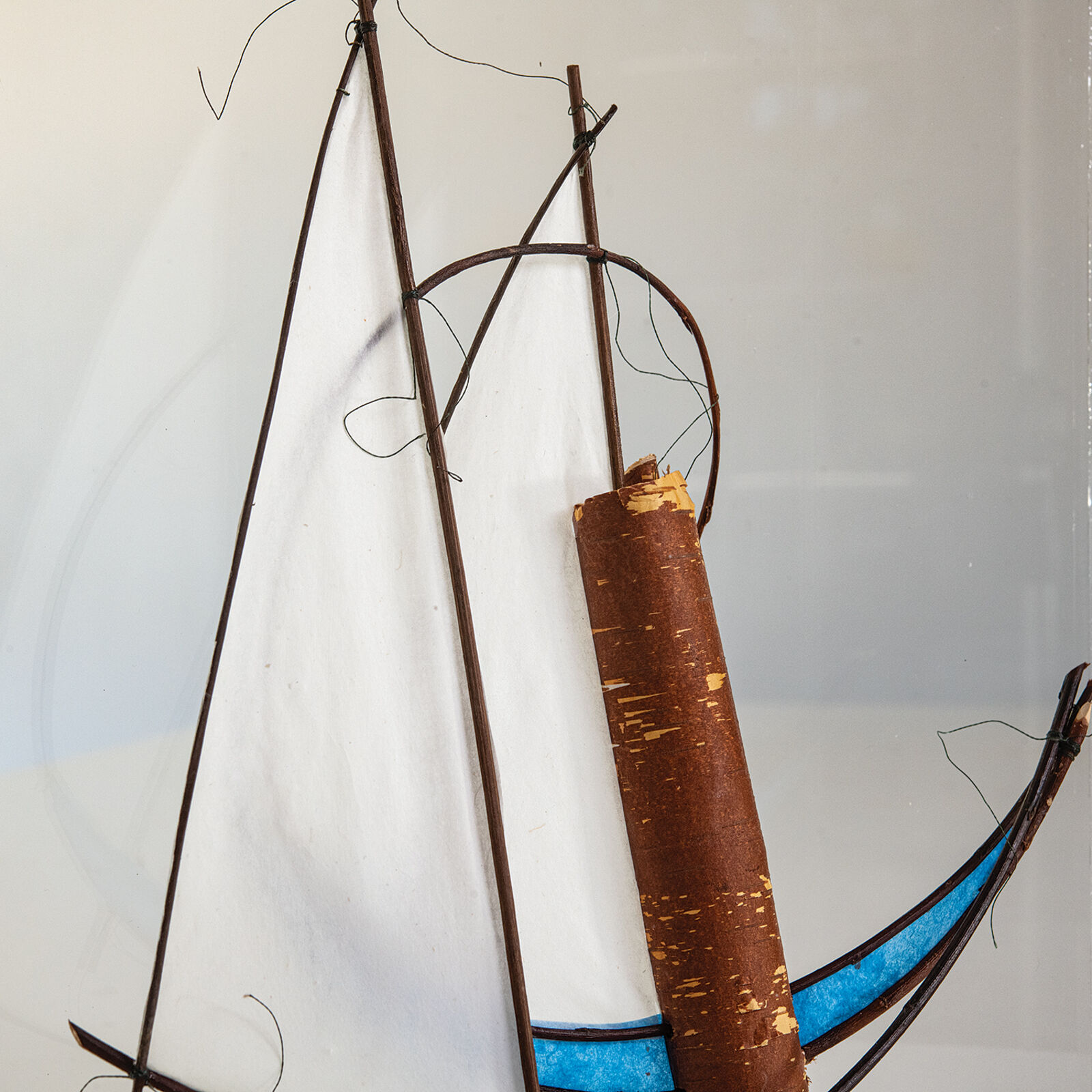 A glass sculpture of a sailboat in a clear box.