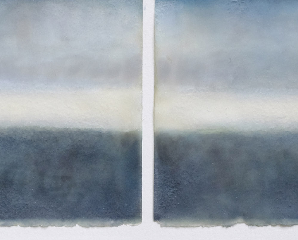 A painting of two blue and white paintings in a white frame.
