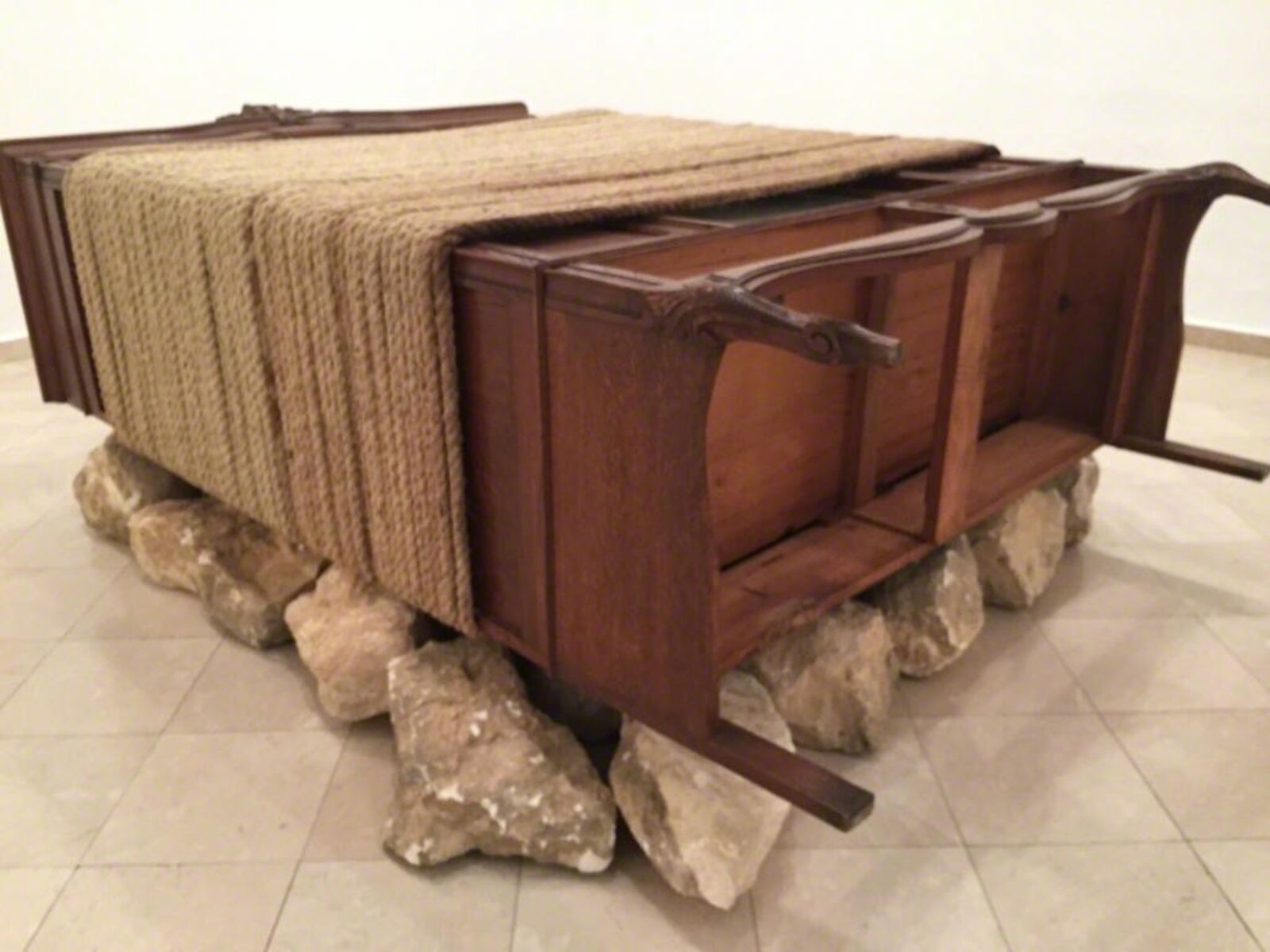 A wooden bench with a blanket on top of it.