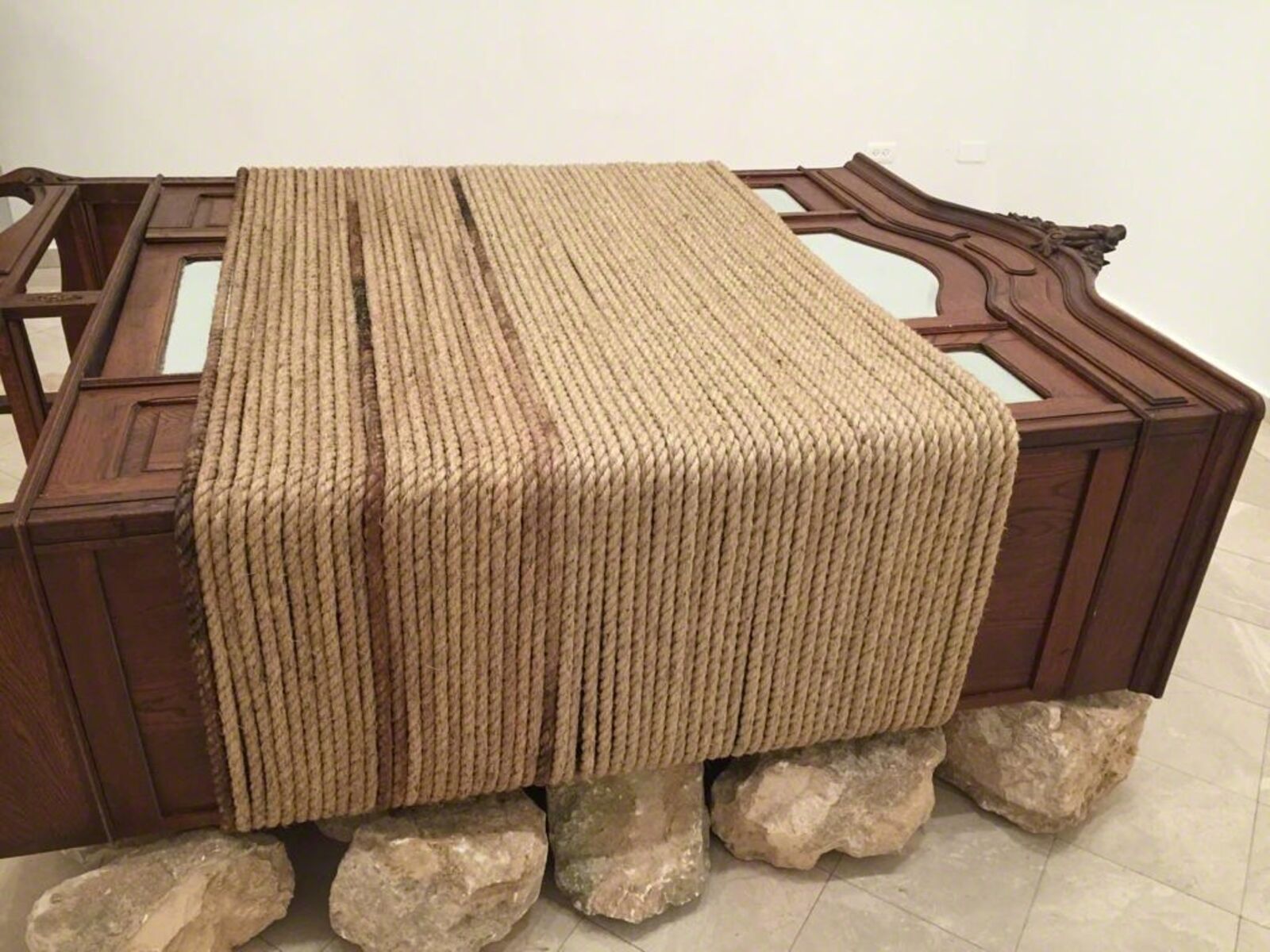 A wooden bench with a blanket on top of it.