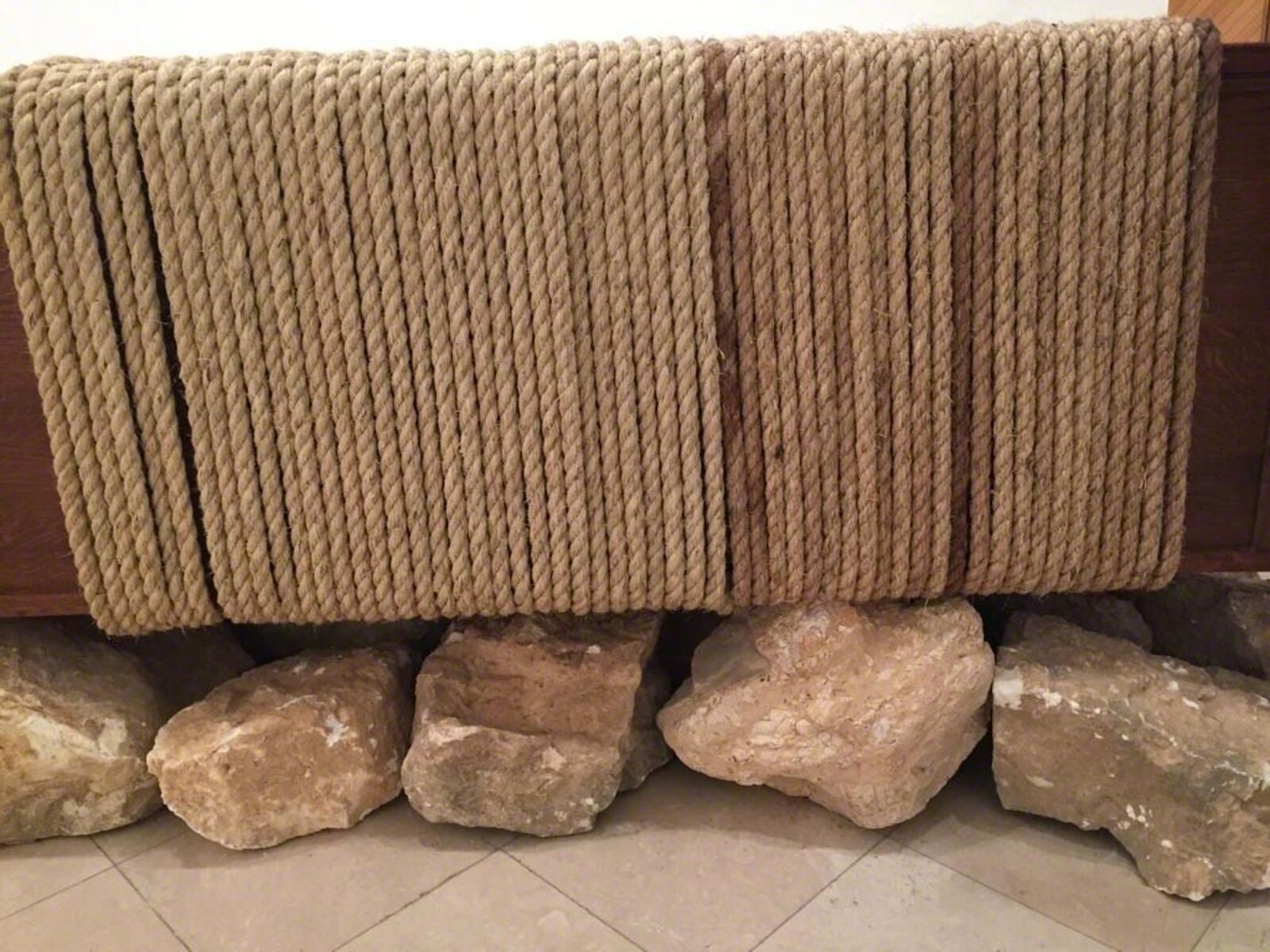 A wooden bench with a blanket on top of it.