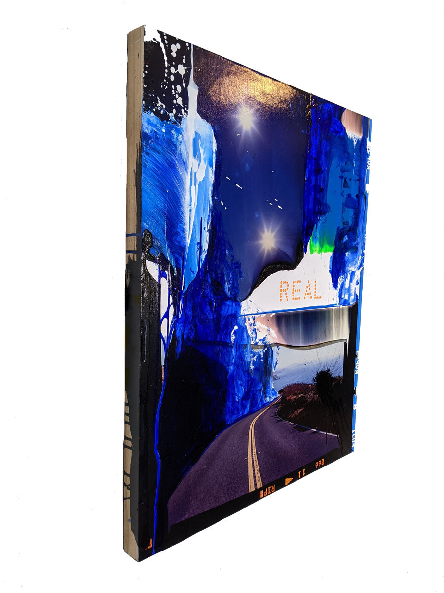 A painting of a road with the word REAL written on it.