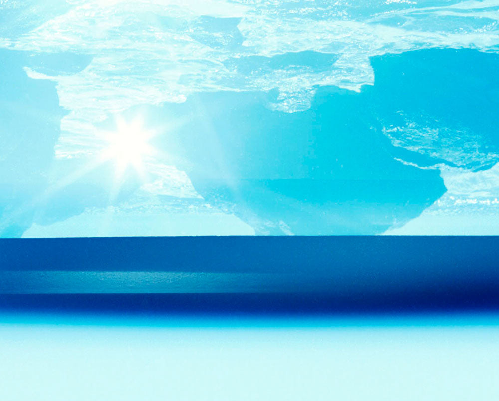 A picture of a blue ocean with the sun shining through the water.