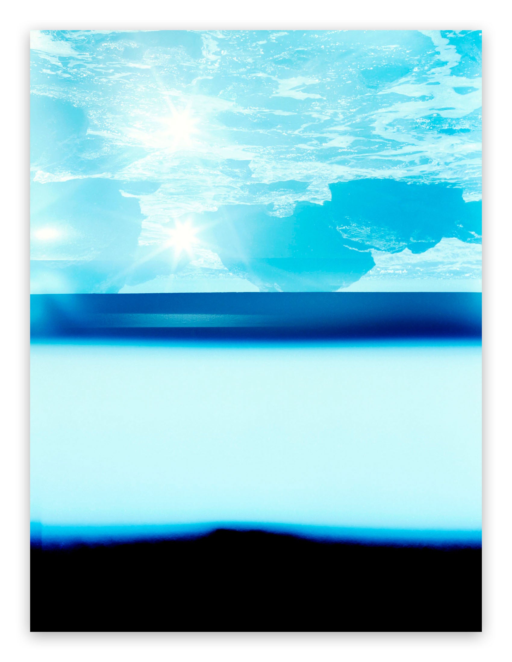 A picture of a blue ocean with the sun shining through the water.
