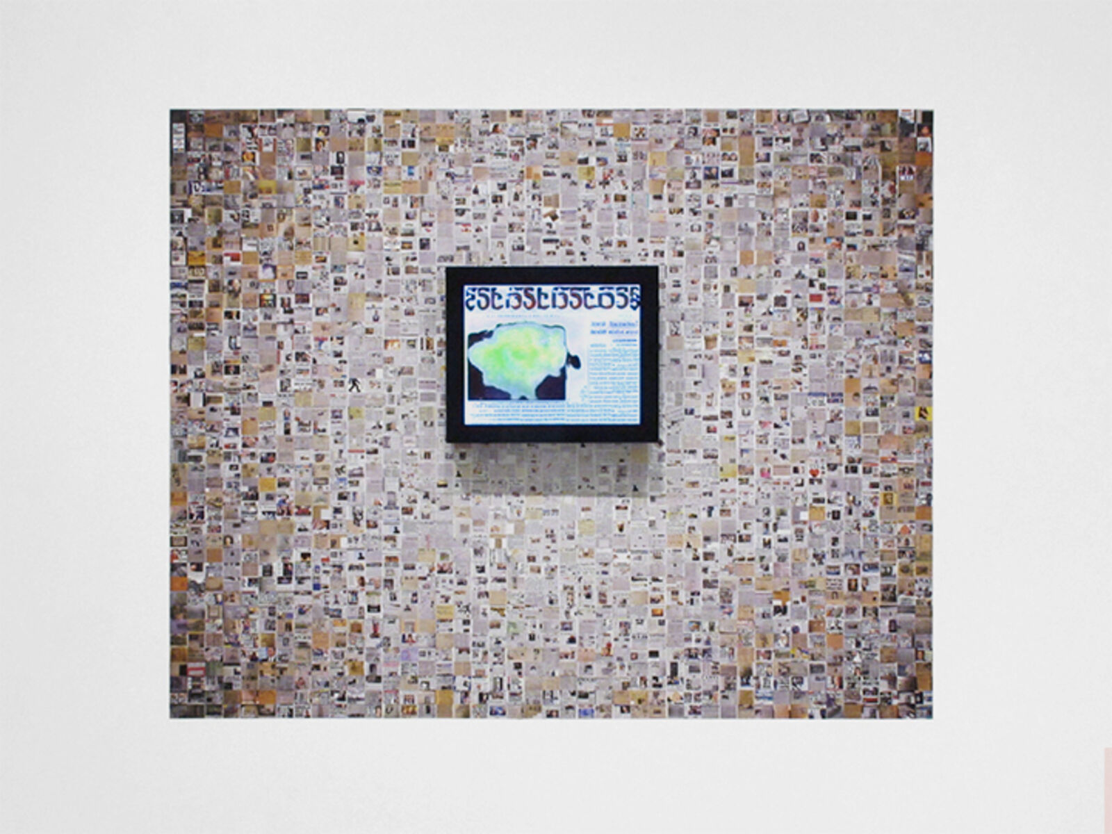A framed colorful mosaic hangs against a wall made of thousands of tiny, varied images.