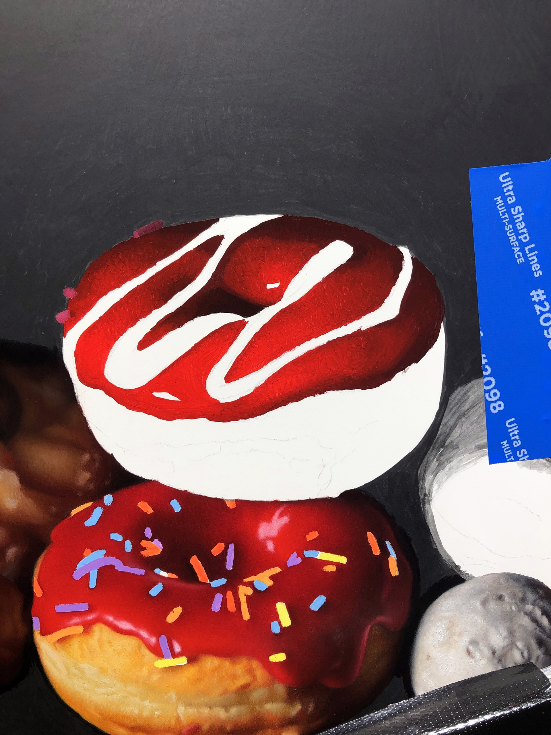 A still life arrangement of colorful donuts and pastries against a dark background.