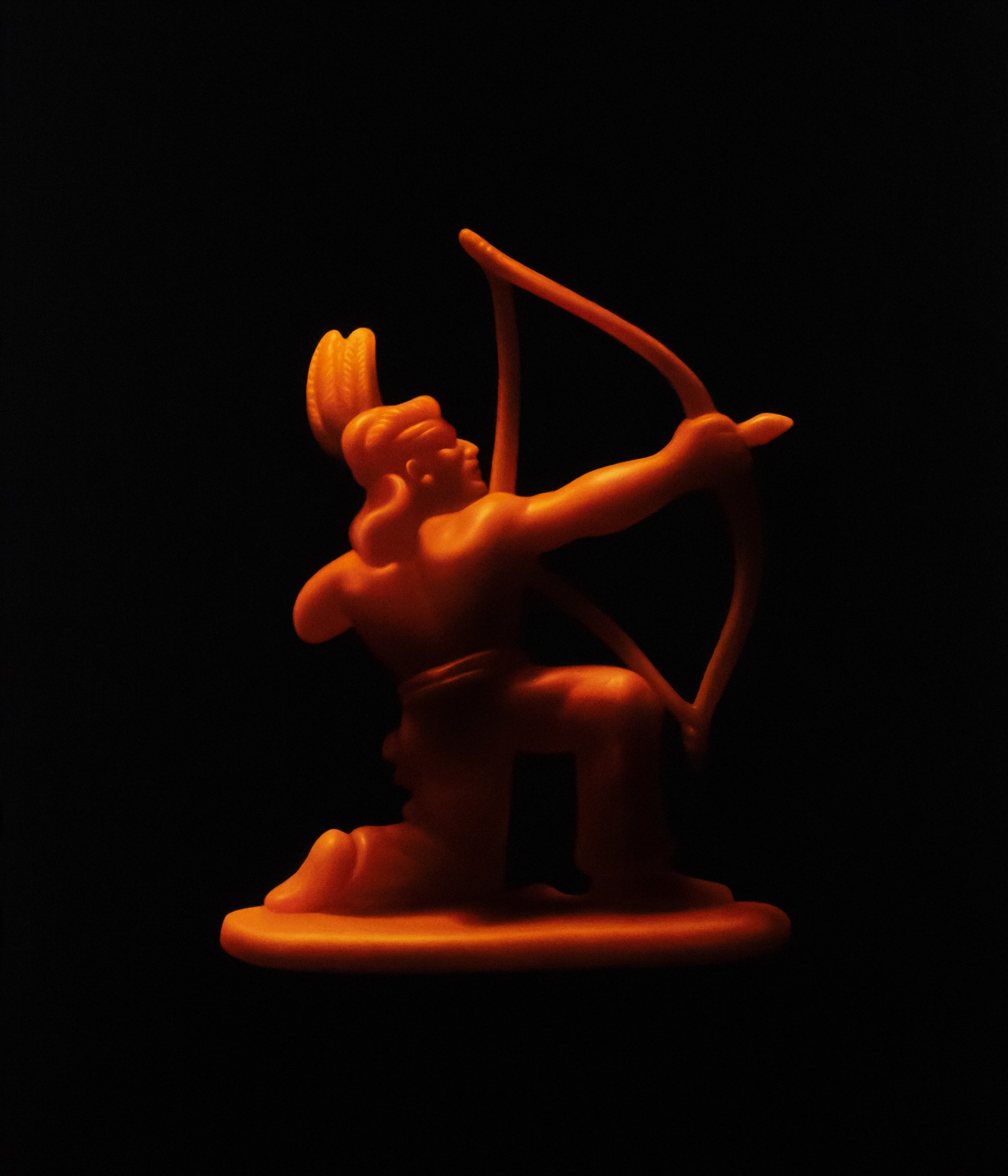 A glowing orange figurine of a kneeling archer holding a bow against a black background.